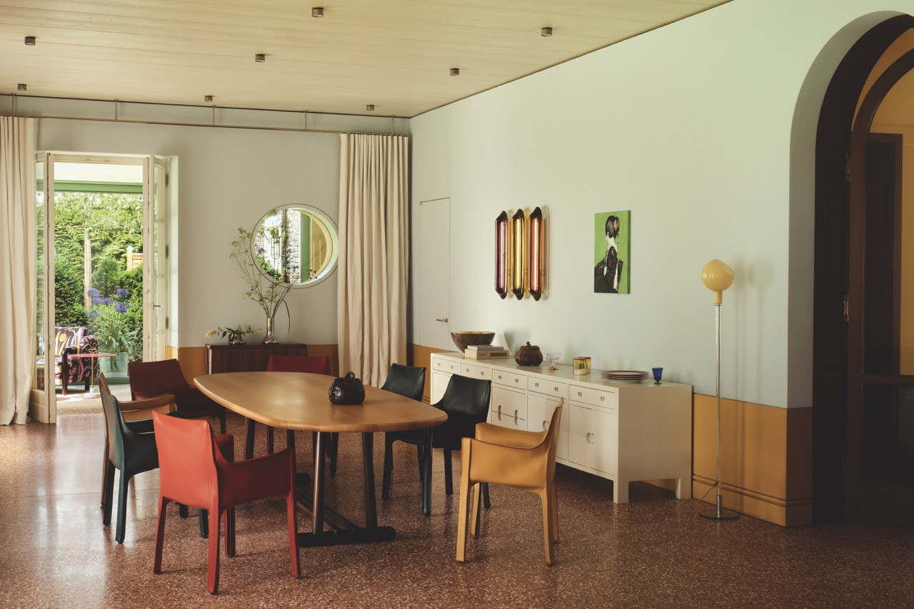 Leather chairs in red, black and mustard surround the oval dining table