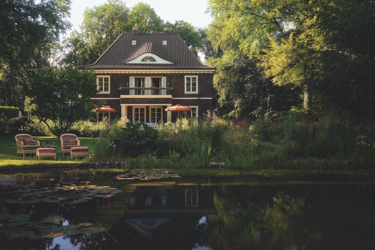 The villa’s rear façade overlooks the lawn and natural pond it was built beside in 1921