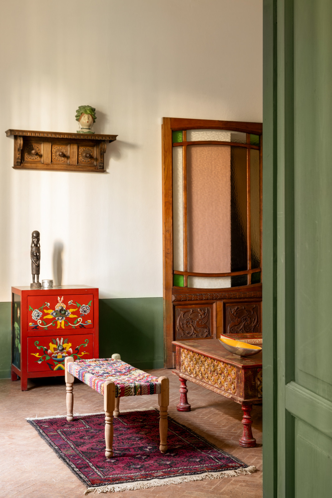 The living area comprises a multicoloured wood-and-rope bench from Morocco and an inlaid coffee table