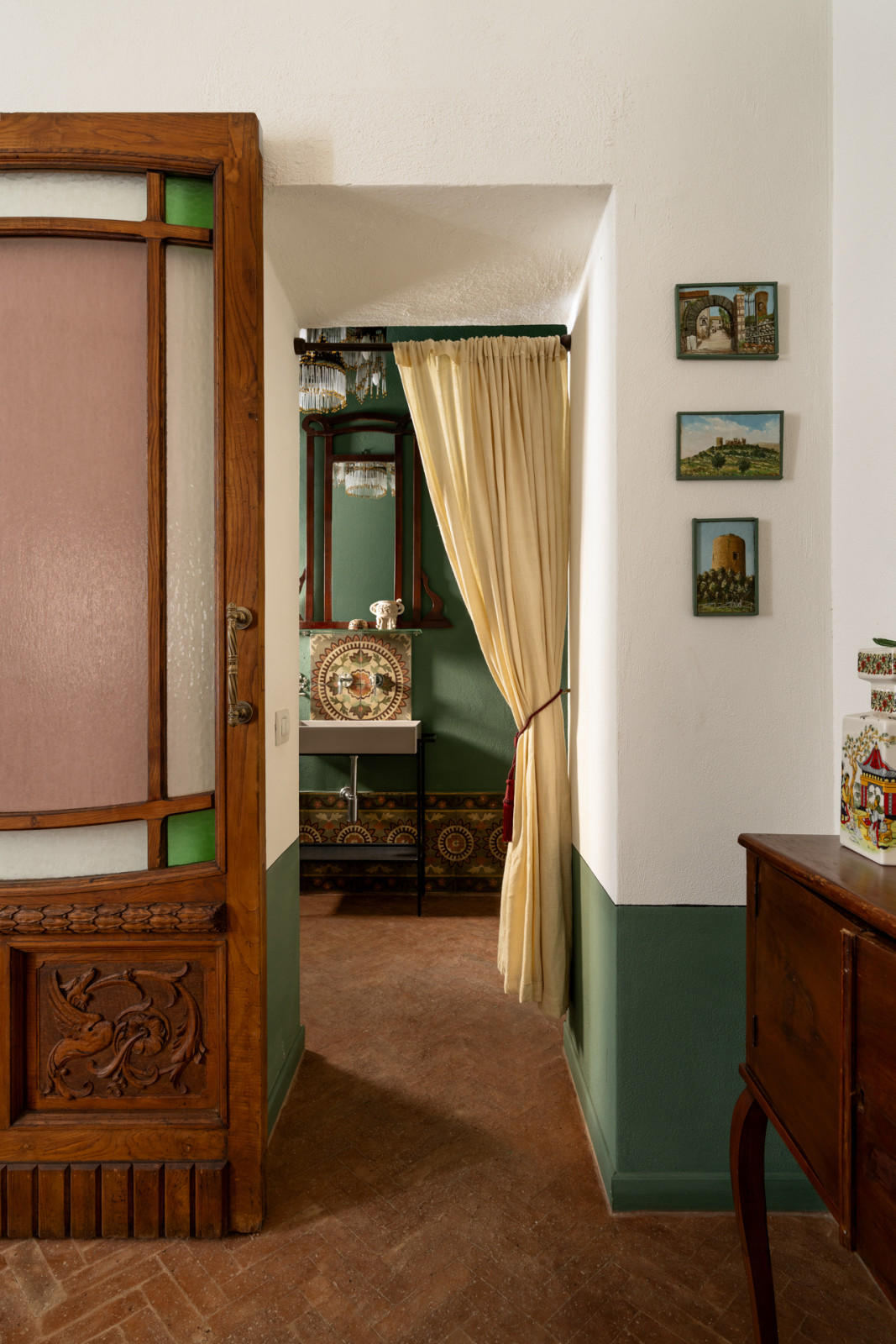 The bathroom with a dual screen comprising an old glass door panel purchased from a junkyard in Naples