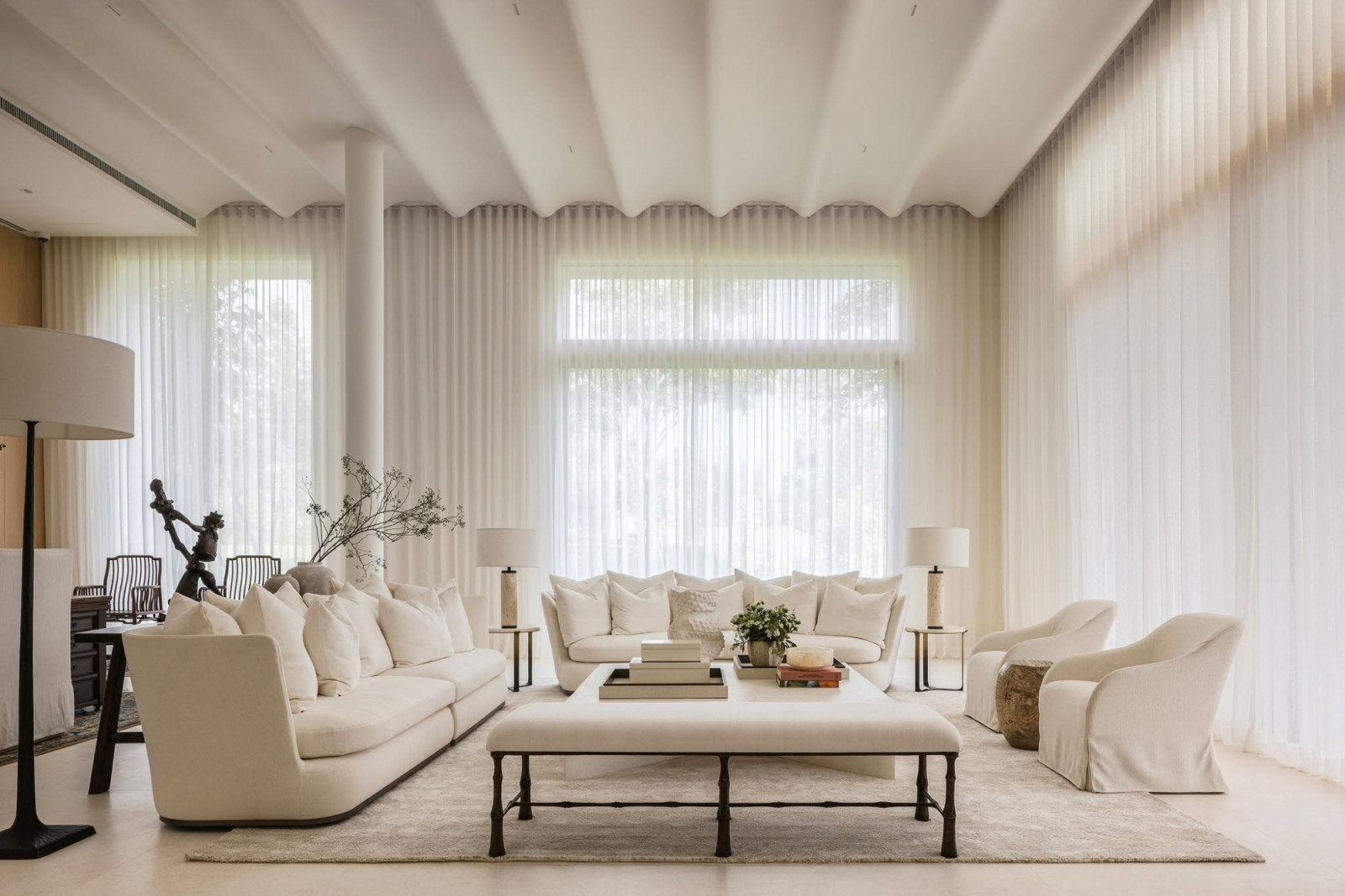 โซนรับแขกหลัก (Main Living Room) เนรมิตความโปร่งเบาด้วยโทนสีขาวสะอาดตาและดีเทลฝ้าเพดานทรงคลื่น ให้ความรู้สึกราวกับนั่งพักผ่อนอยู่บนก้อนเมฆ (ภาพ: Onion)