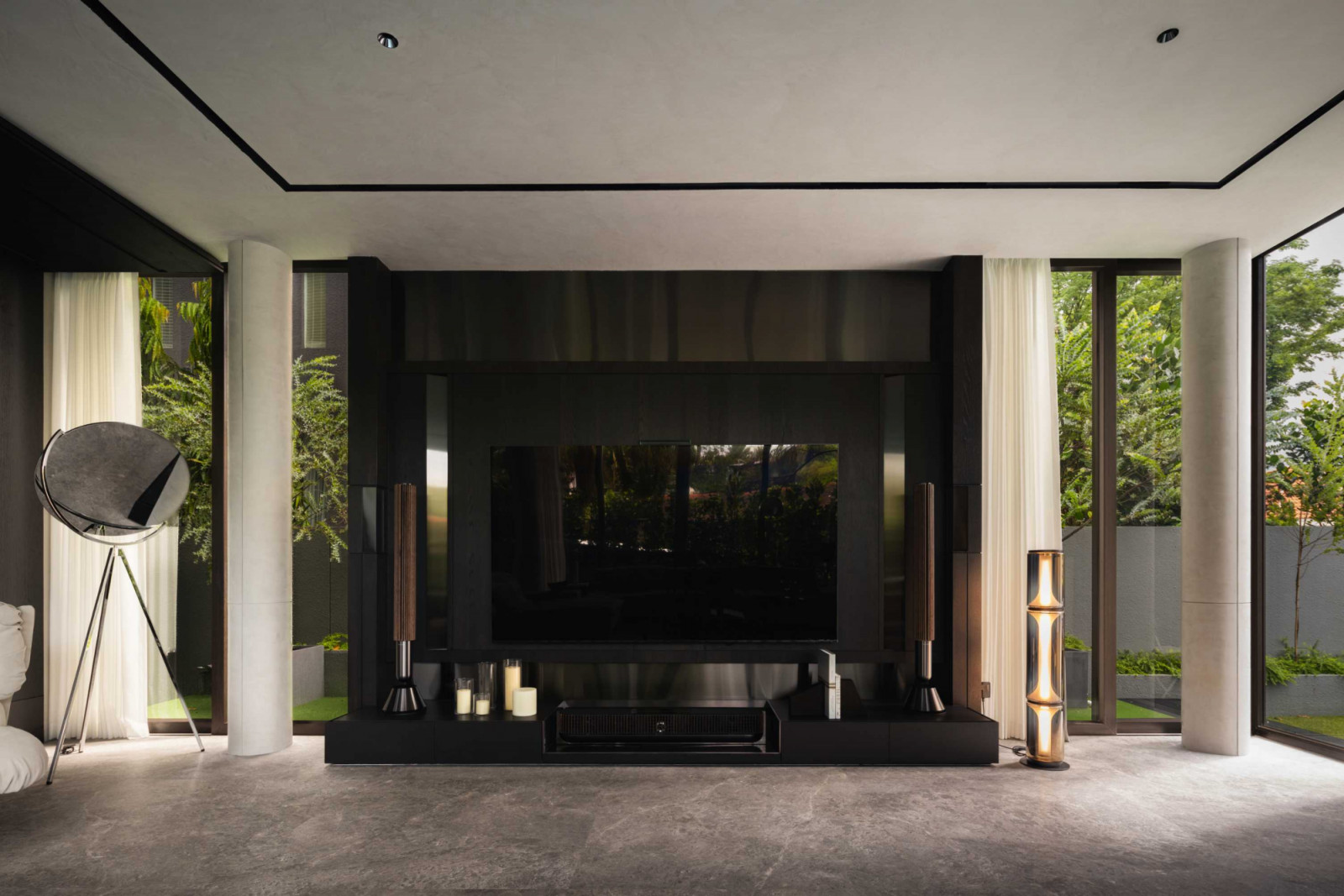 The entertainment room’s speaker system is concealed within a sleek, dark media wall