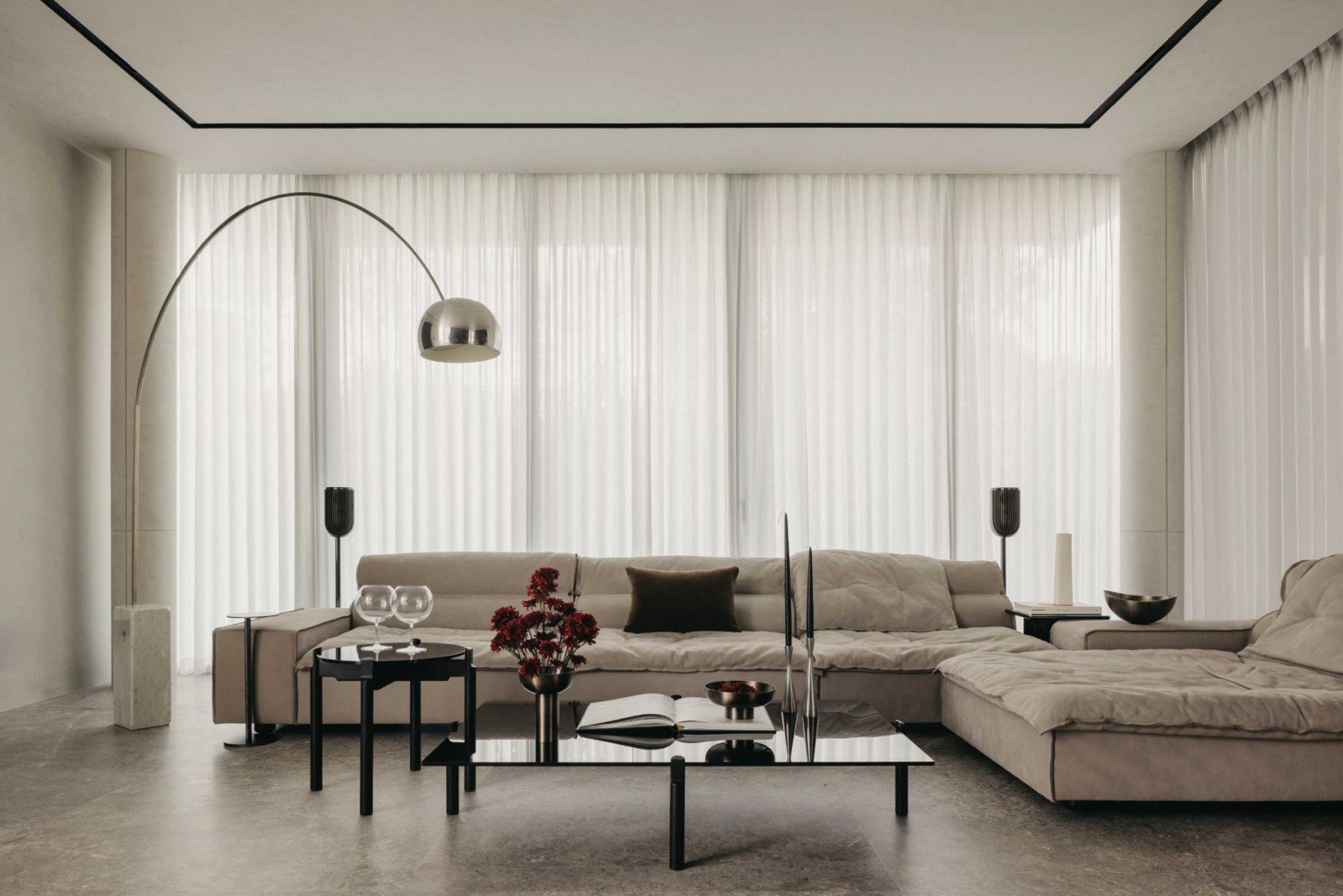 Stone and dark timber invigorate the living room, which also features a plush sofa and sheer curtains