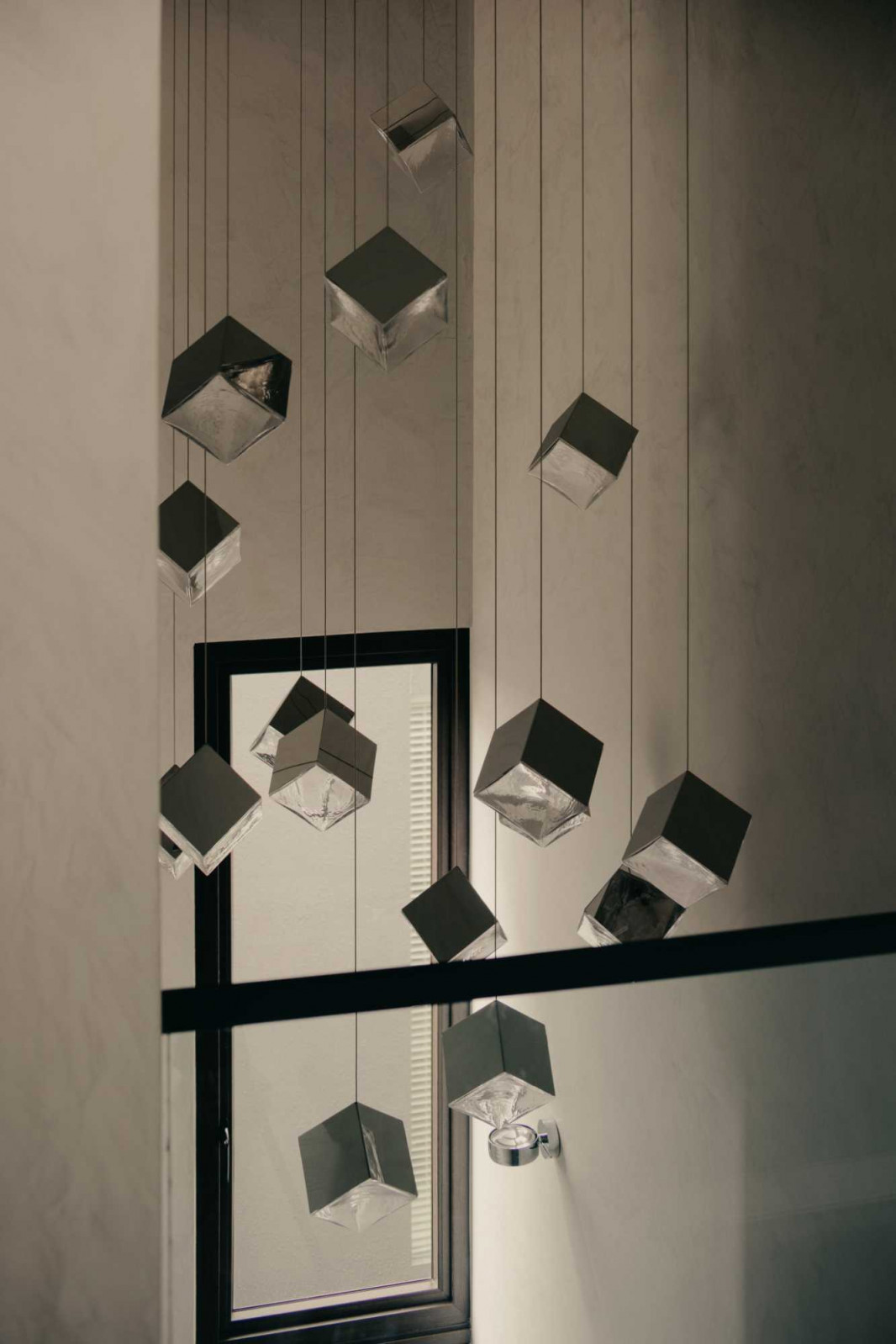 These cube-shaped pendants catch the light along the staircase void