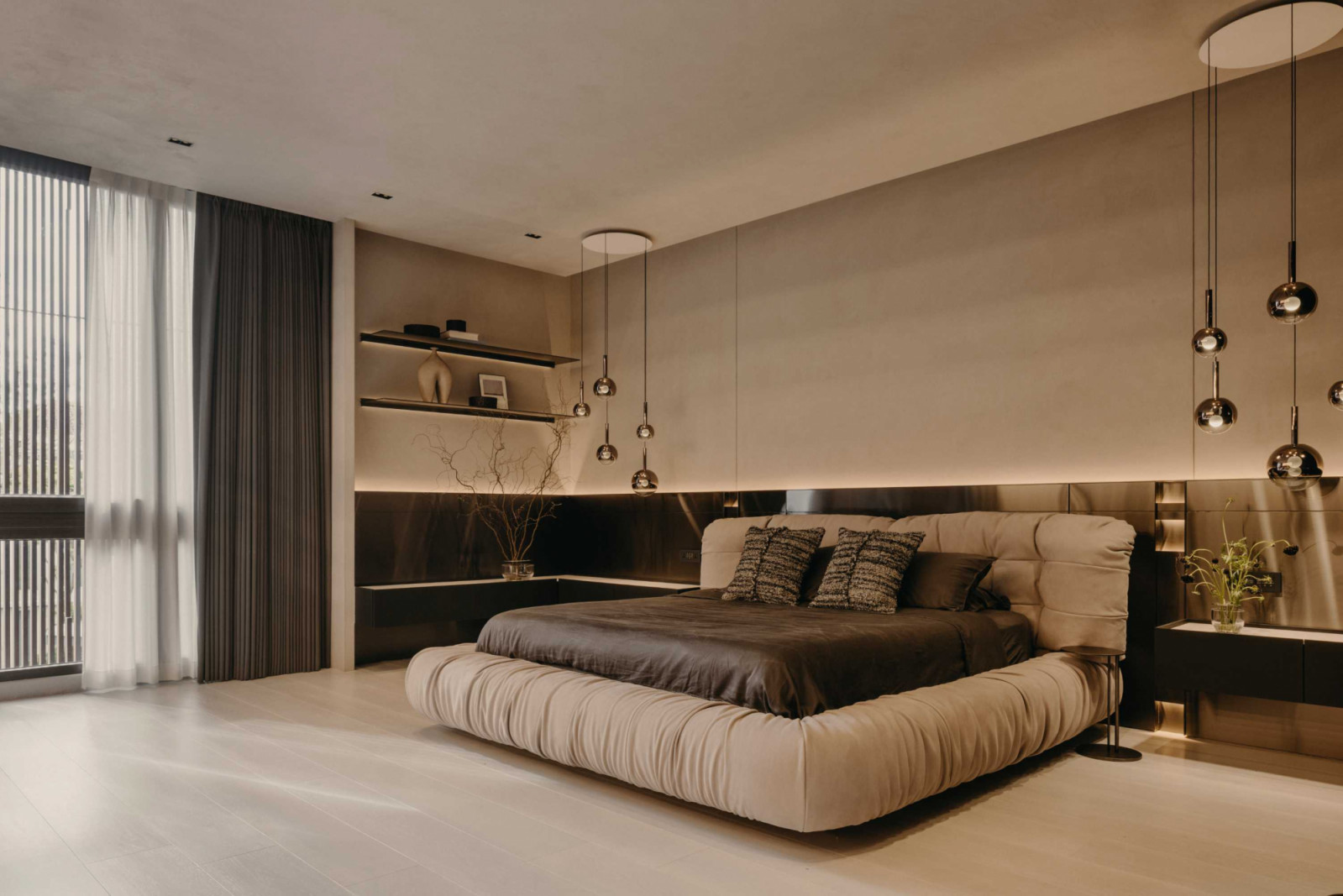 The master bedroom’s Baxter bedframe conveys elegance and comfort beneath cascading pendant lights