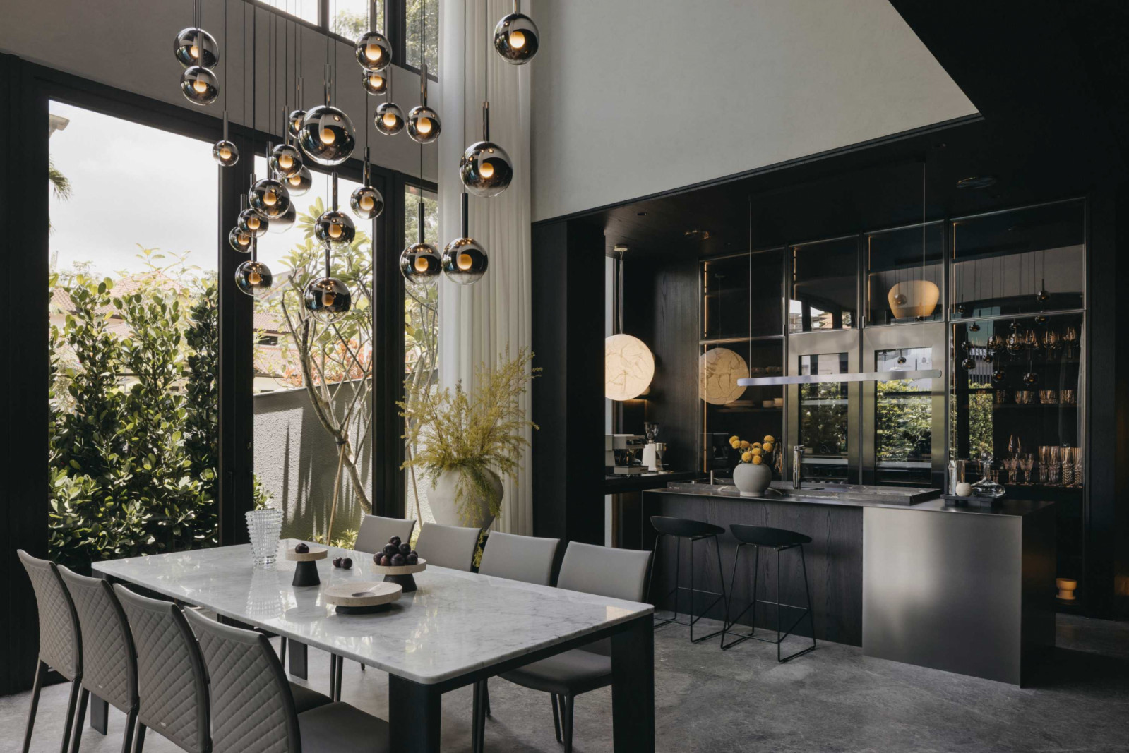 The detached house’s double‑volume dining area features Occhio pendant lights