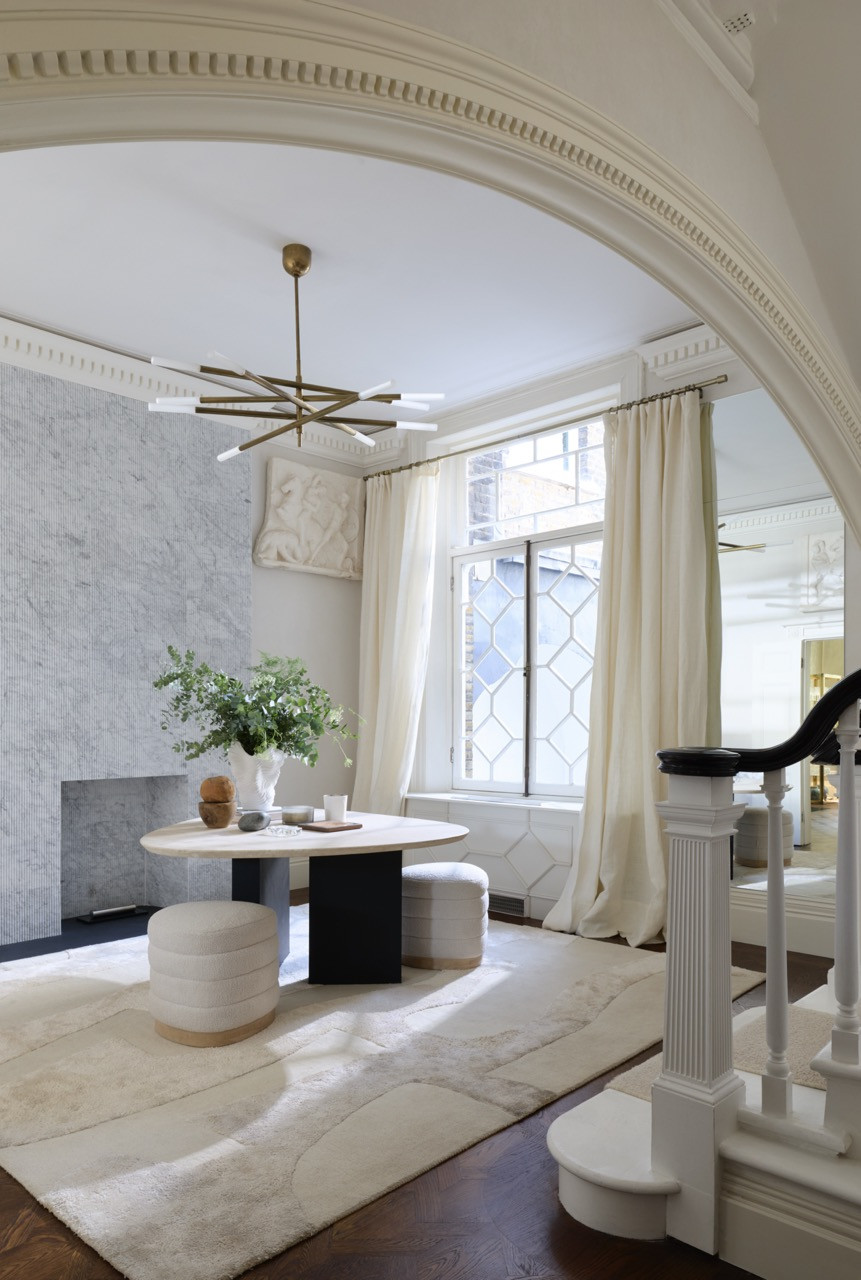 Seen through the arch, the lobby’s fluted marble fireplace was built from Lusso tiles mitred at the edges to read as solid stone