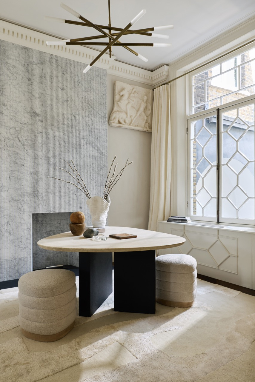 The lobby’s organically shaped table, from Dara Maison, sits with ribbed bouclé stools beneath a brass chandelier