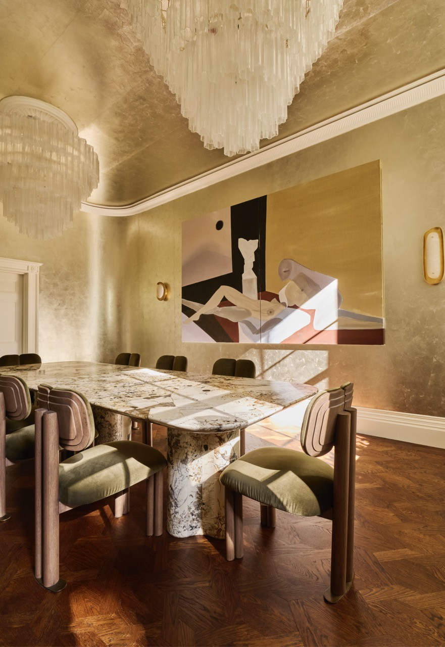 The dining room’s metallic finish extends onto the ceiling, while a large figurative painting by Kristen Giorgi anchors the far wall