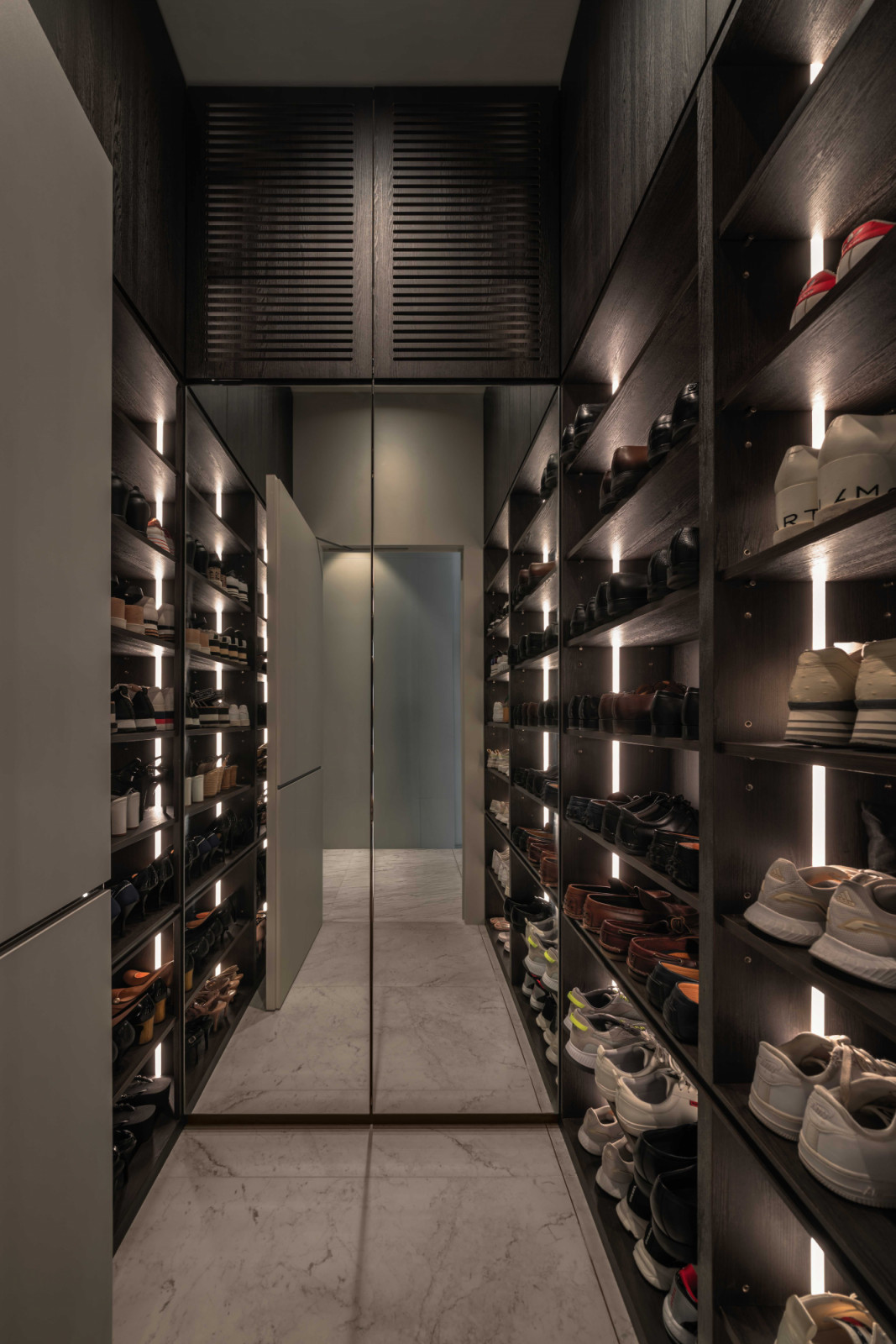 Inside the hidden walk-in shoe storage room, which blends into the entrance hallway on the outside