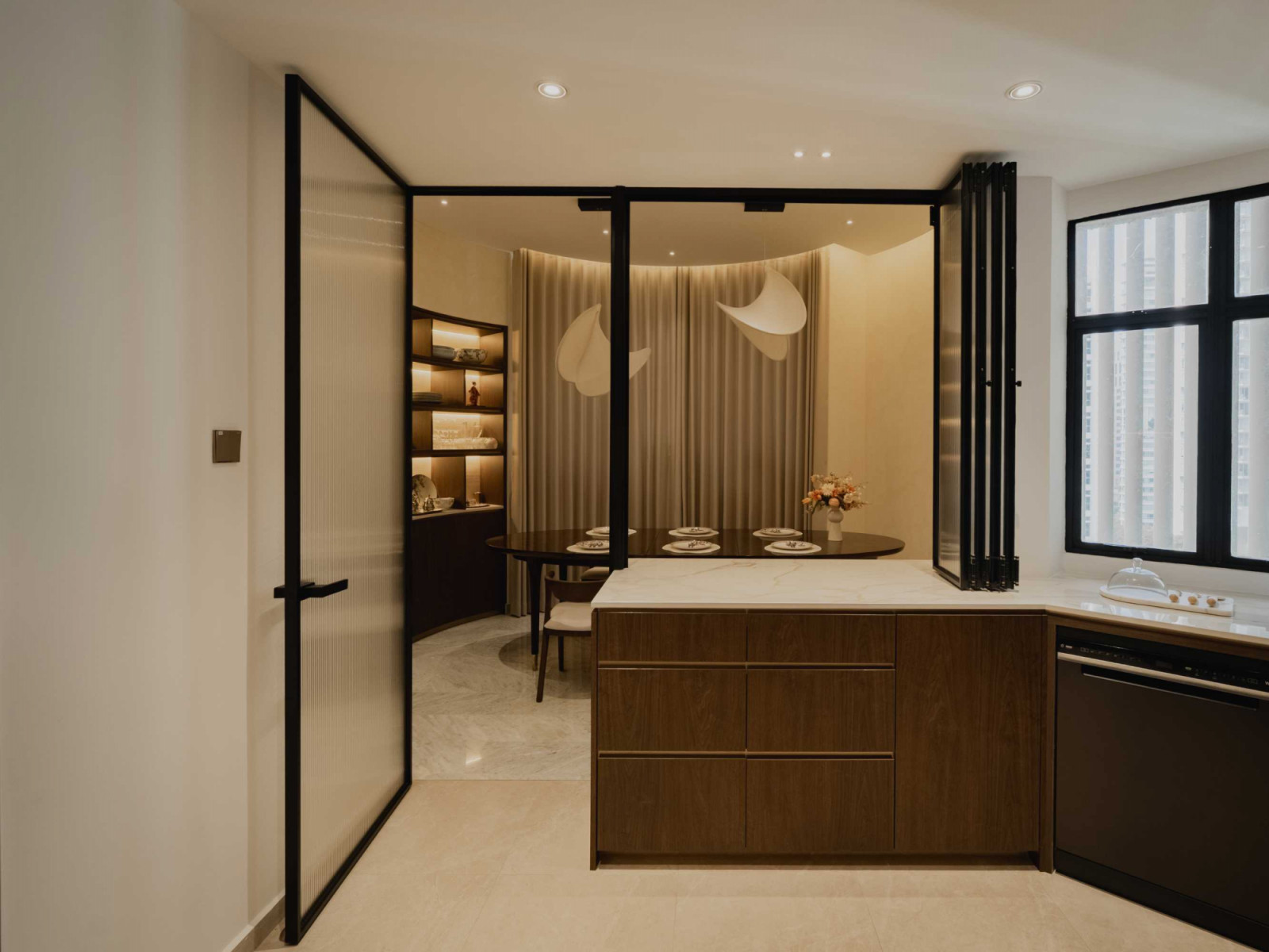 A peek at the dining area from the kitchen, with the liberal application of glass allowing light to flow freely between both areas