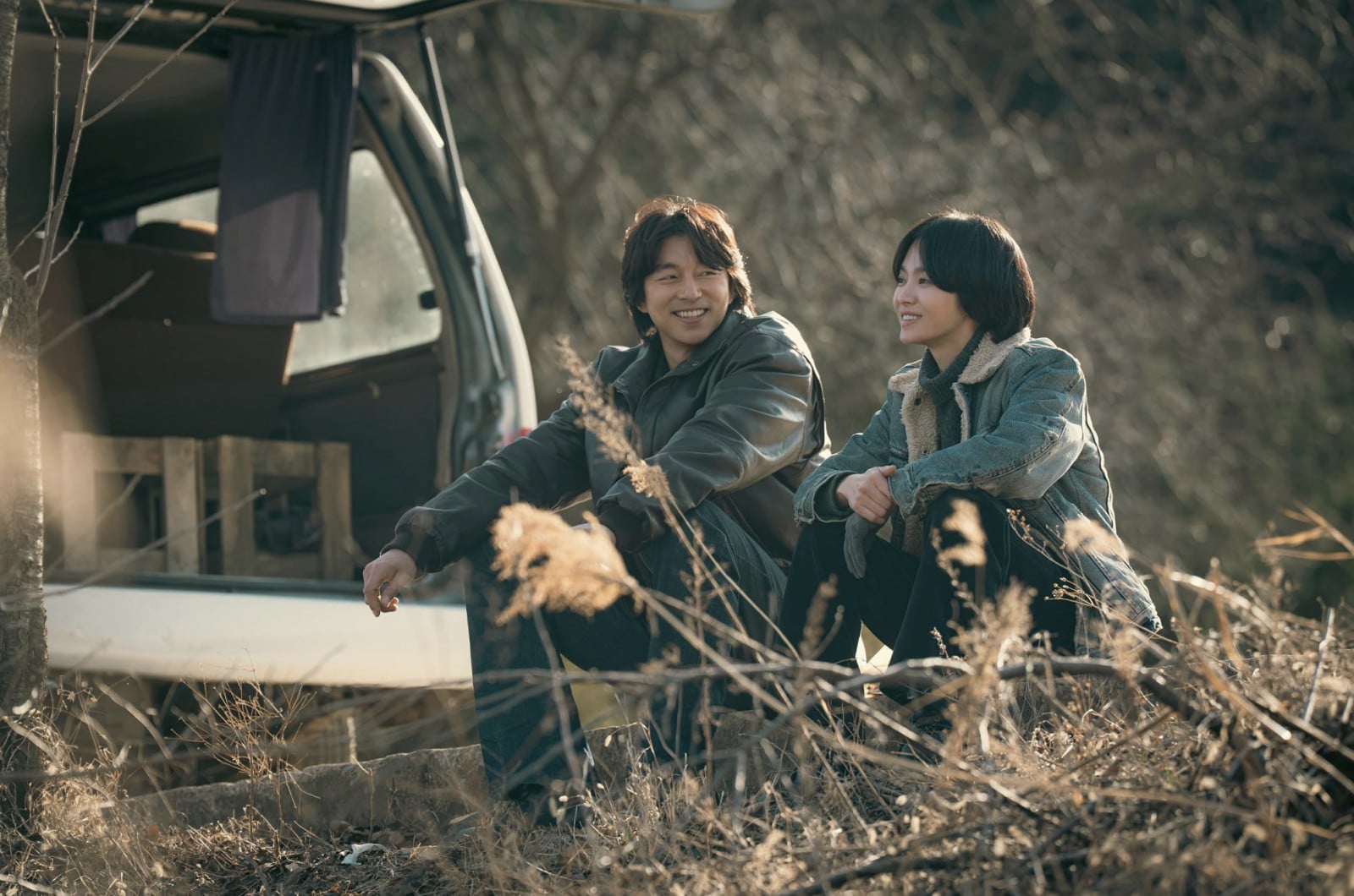 Two smiling characters from a South Korean drama share a quiet moment outdoors.