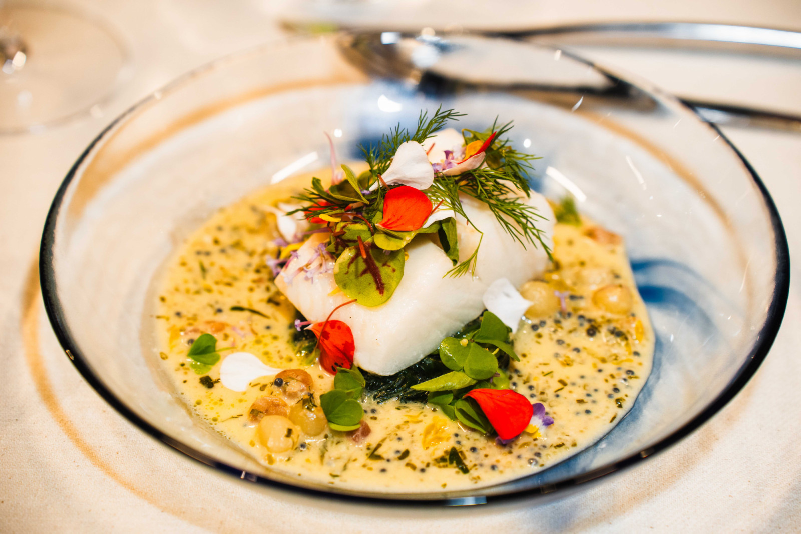 Olive oil-poached Greenland halibut with caviar chive beurre blanc, baby spinach and potato pearls