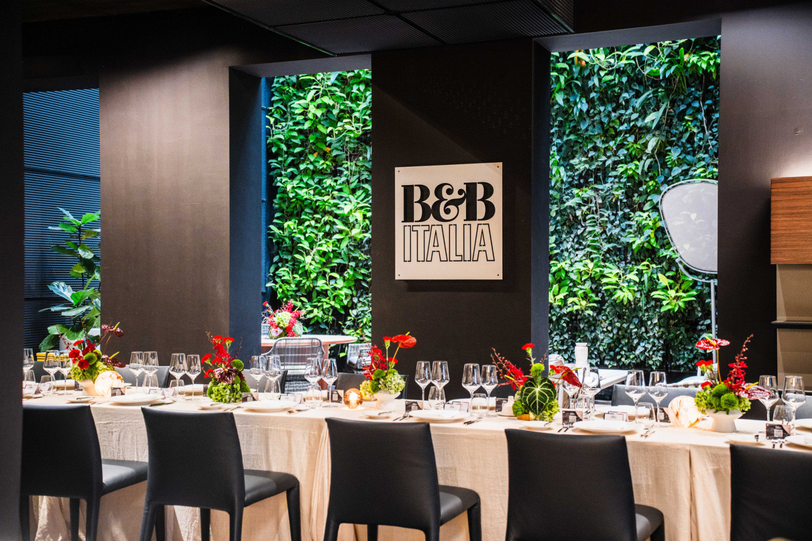 A beautifully appointed table, with glimpses of the B&B Italia Outdoor collection and a living green wall beyond
