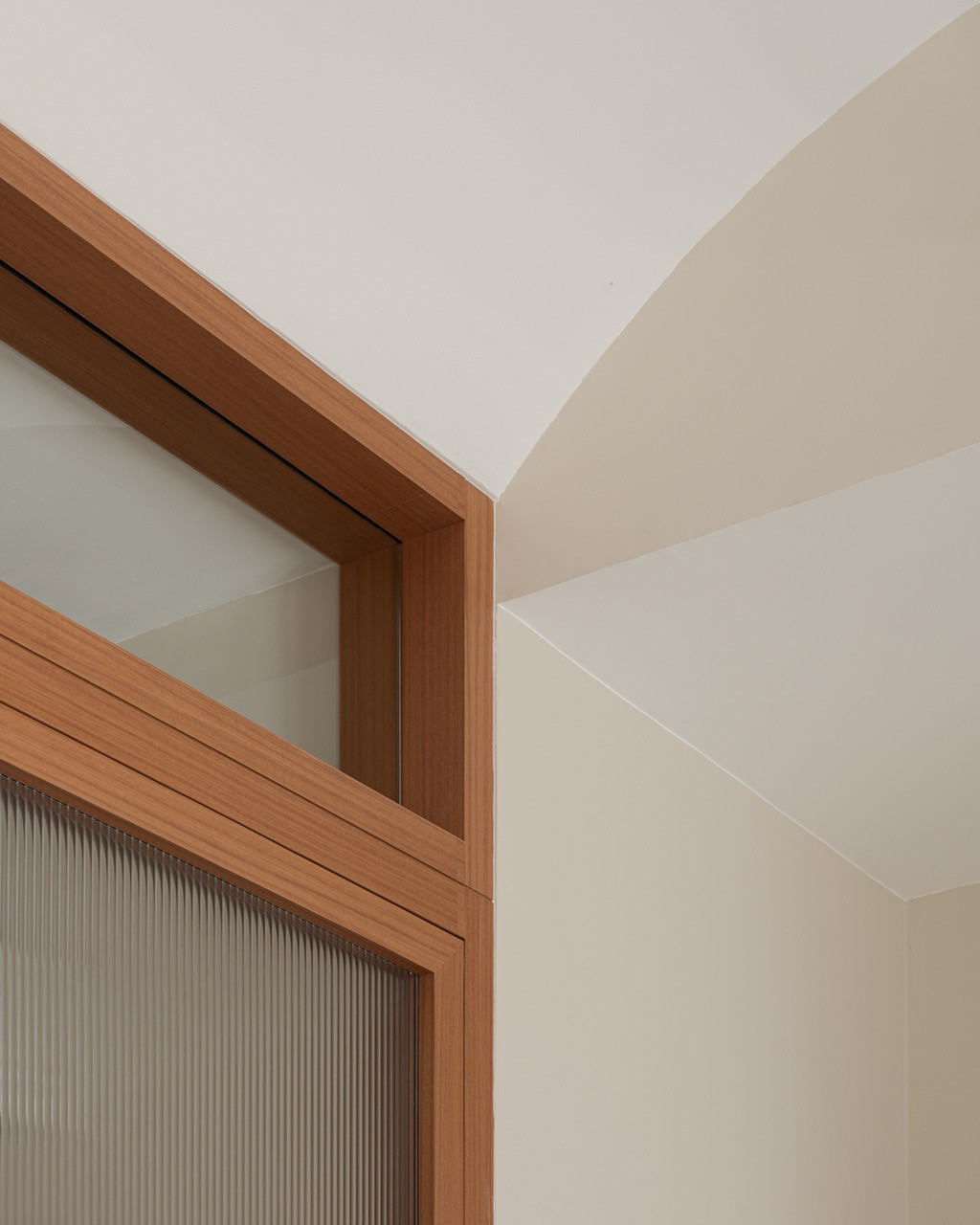 Where the timber door frame meets the ceiling, the plaster curves into a soft vault