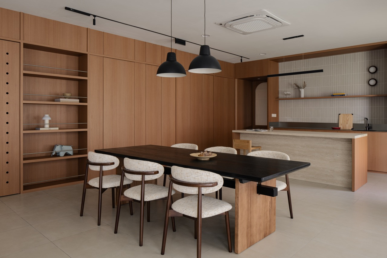 The open-plan ground floor holds the dining area and kitchen island, with full-height storage along one wall