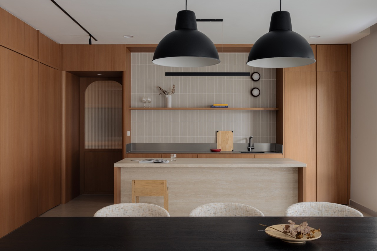 A sintered stone island stands between the dry kitchen and the dining table