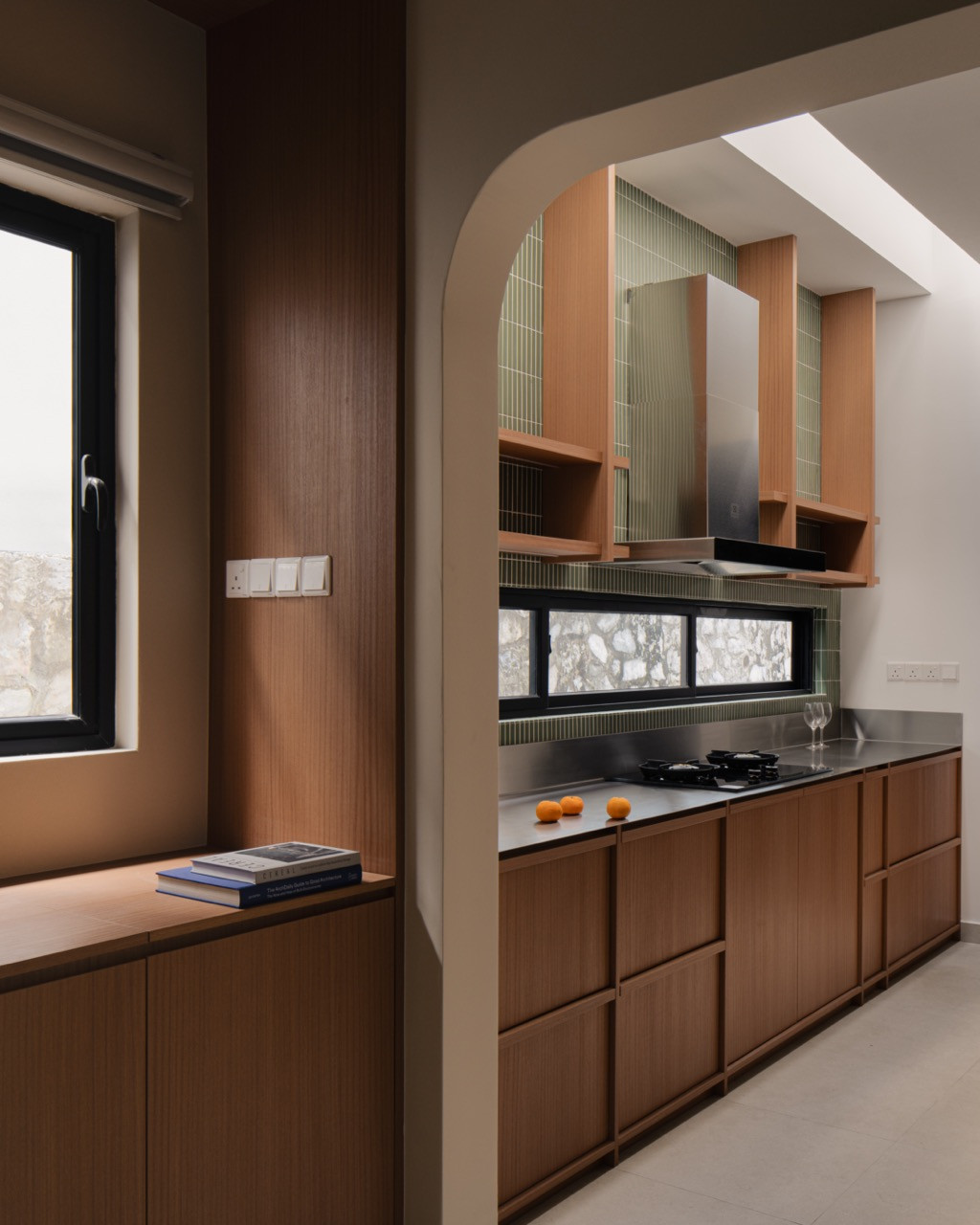 An arched opening frames the wet kitchen, where open shelving flanks the cooker hood