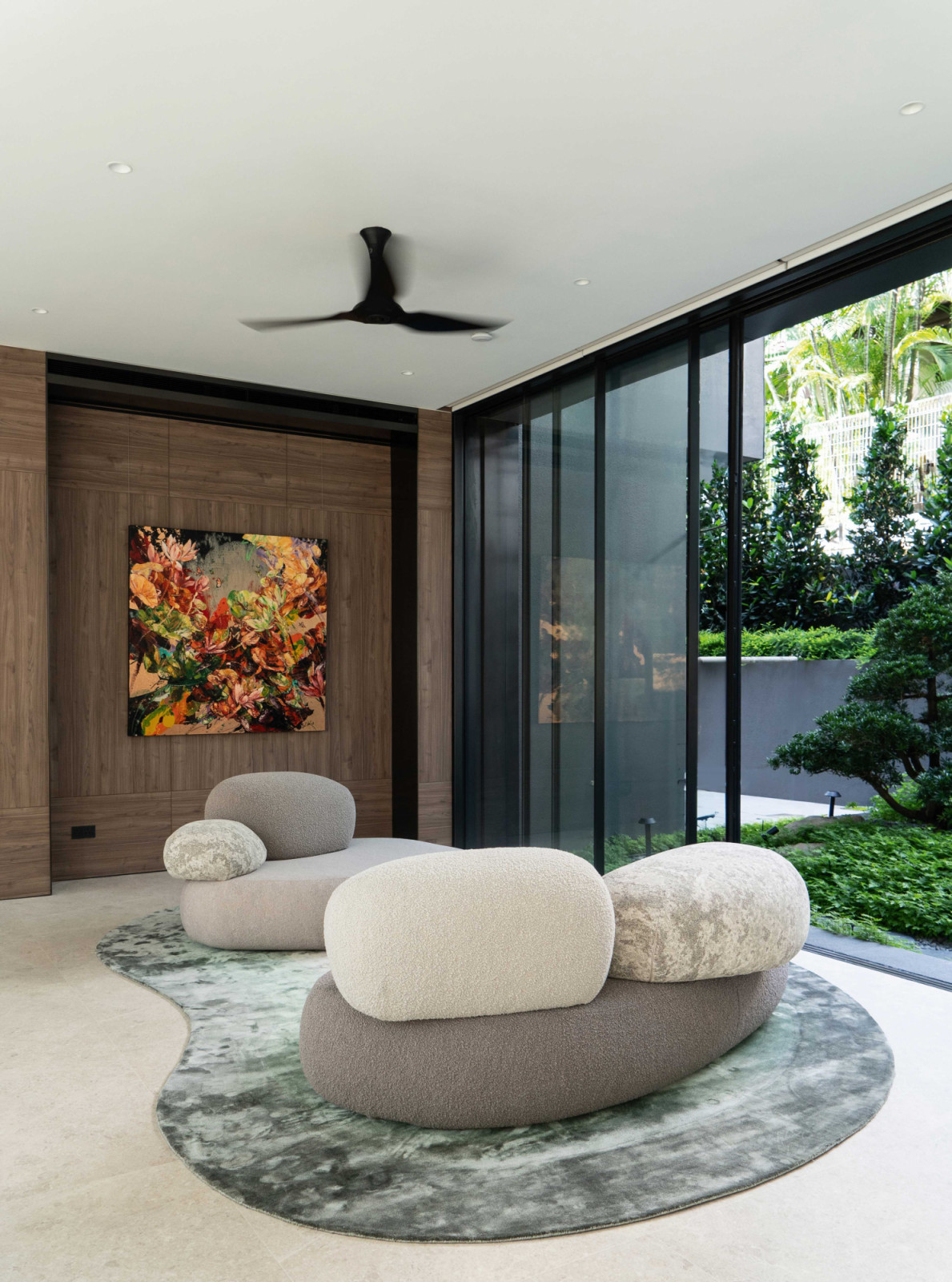 A custom pebble-shaped rug in a beige and green gradient, designed to suit the interior