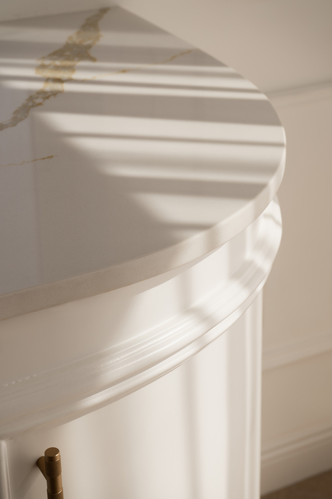 White quartz surfaces and backsplashes are accented with subtle gold veining