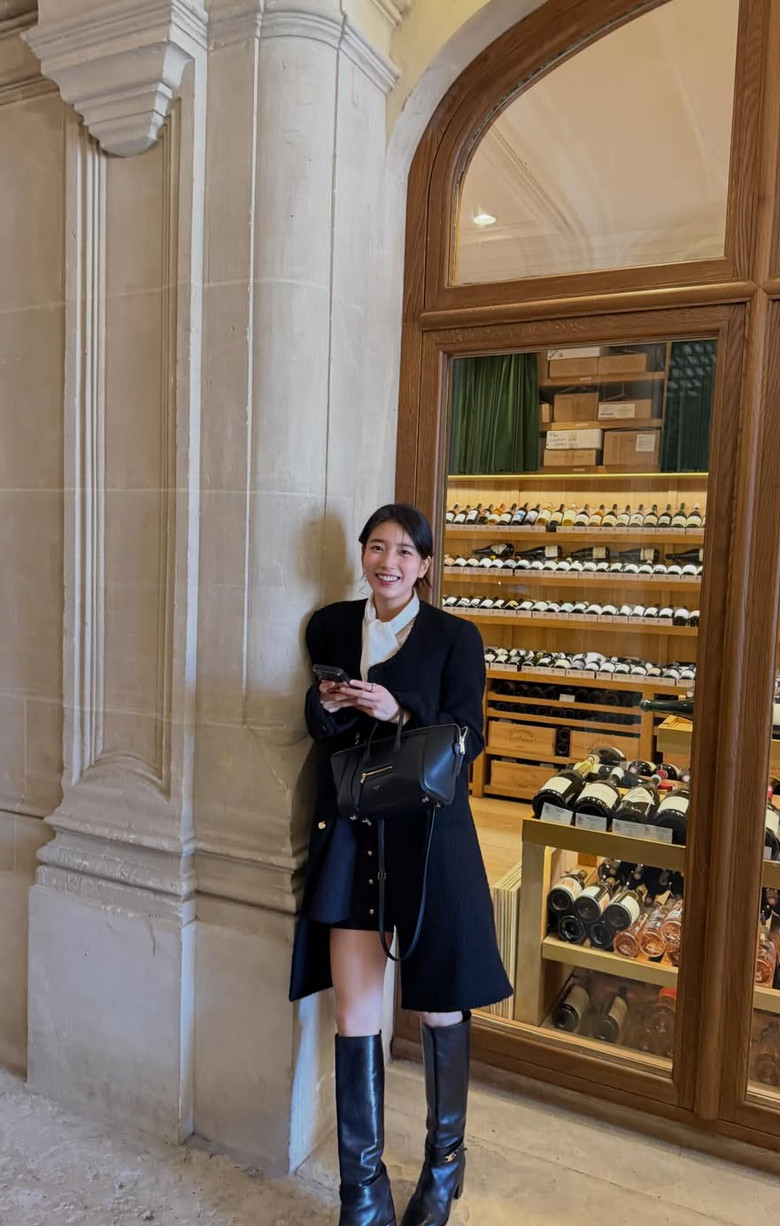 Bae Suzy, the South Korean actress and singer, exudes sophistication beside a curated wine collection.