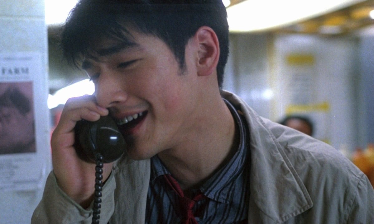 Takeshi Kaneshiro, the actor, smiles while talking on the phone.