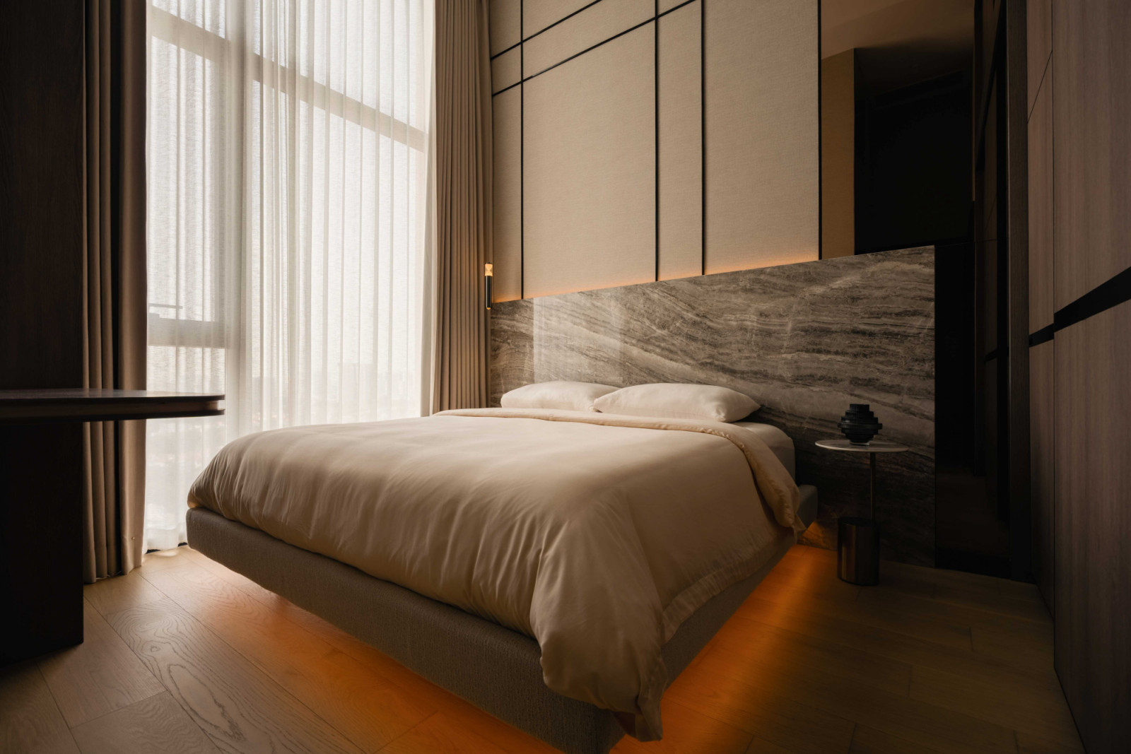 The master bedroom, with its marble bed head and asymmetrical tinted mirror