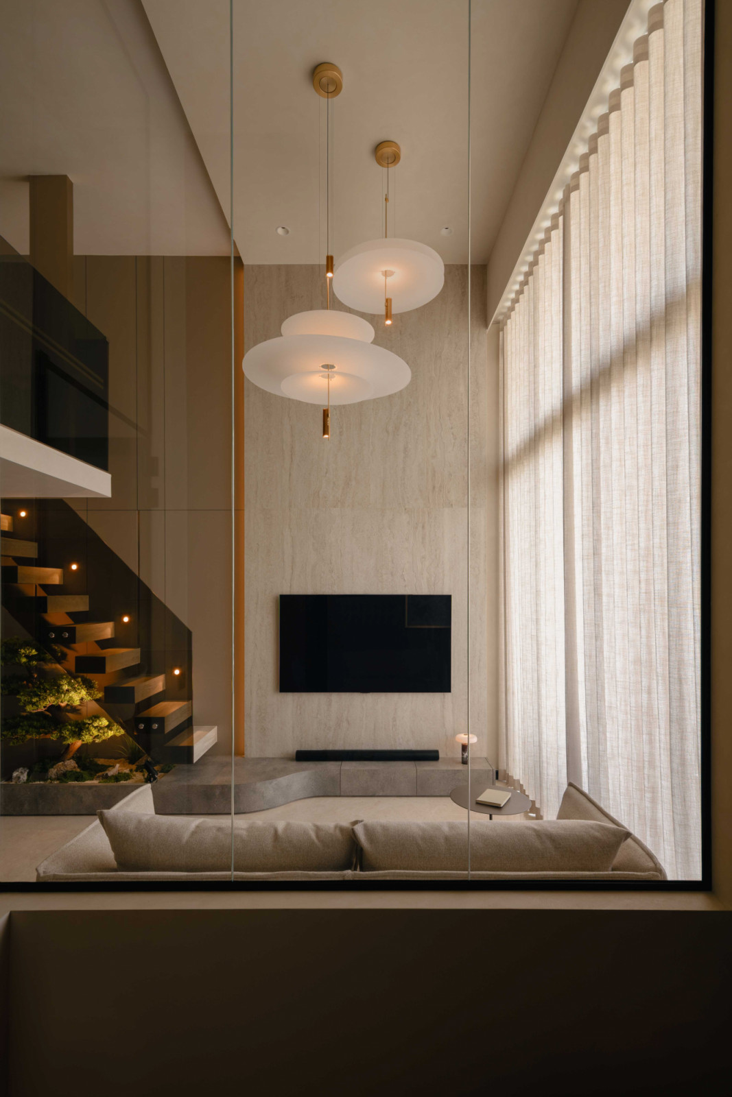 Large-format mirrored panels of the double height living rooms makes it visually larger