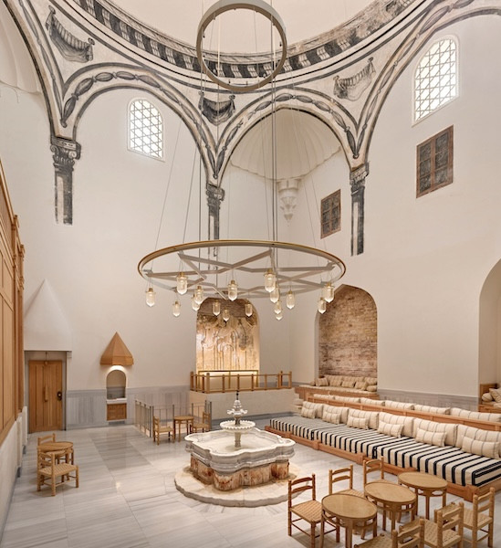 The domed entrance hall, where bathers rest after the bath, with a marble fountain and restored painted decoration on the arches