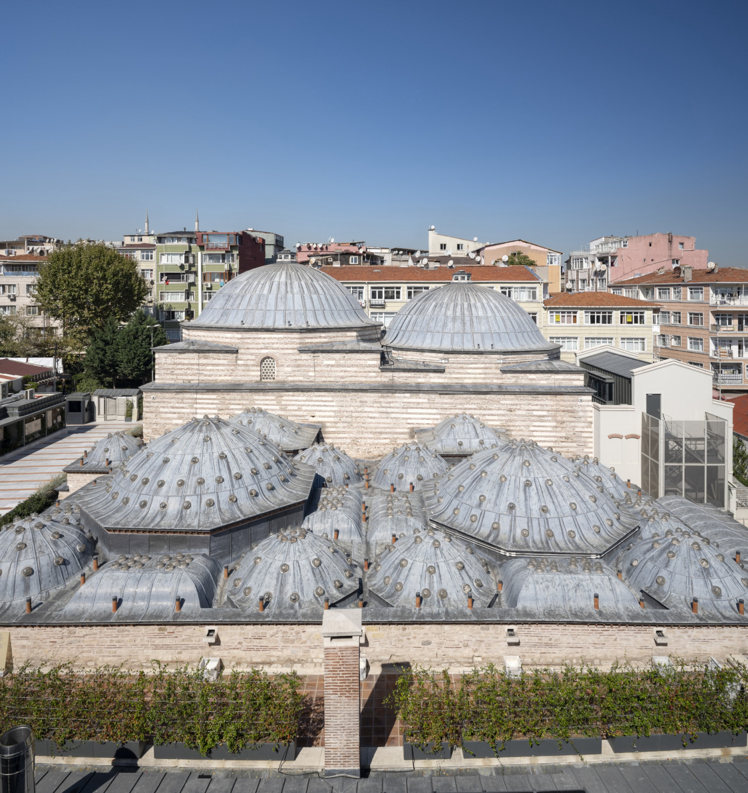 The lead-clad domes of Zeyrek Çinili Hamam, studded with glass oculi, rise among the apartment blocks of Zeyrek, a UNESCO World Heritage neighbourhood