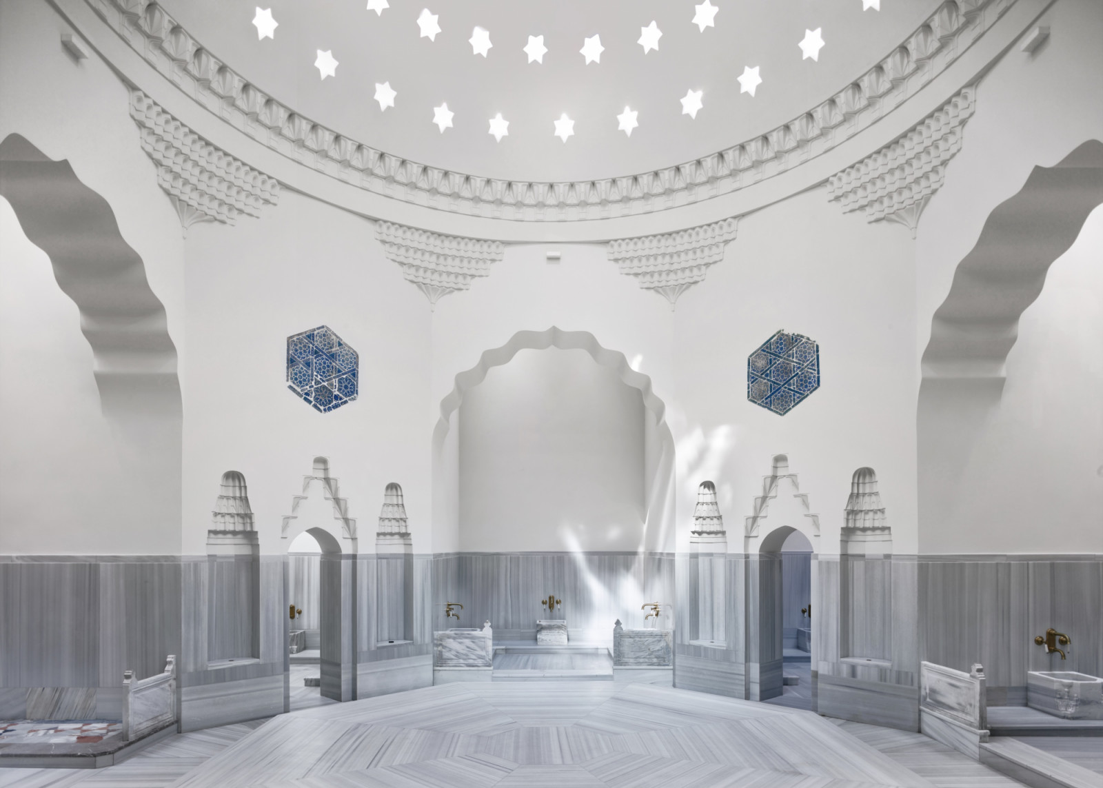 The restored hot room of Mimar Sinan’s 16th-century bathhouse, with marble basins, scalloped arches and hexagonal panels of İznik tiles beneath the star-pierced dome