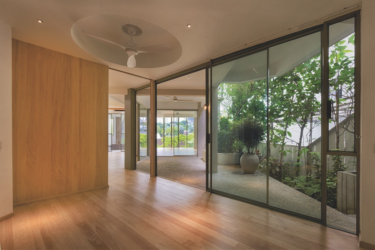 Timber flooring and full-height glass doors dissolve the boundary between the middle level and its adjoining garden