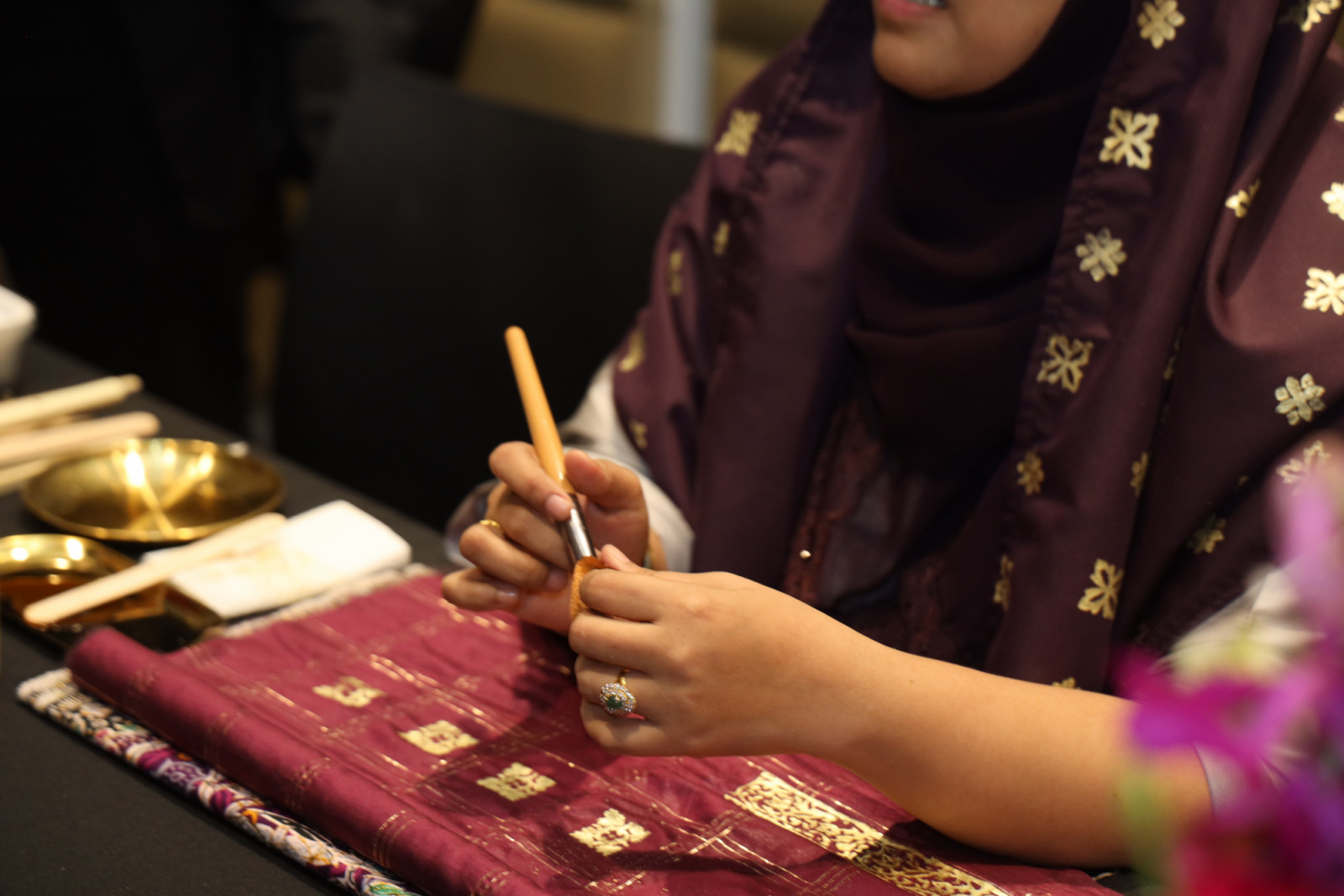 A demonstration of the traditional textile art of ‘telepuk’ using gilded gold leaf