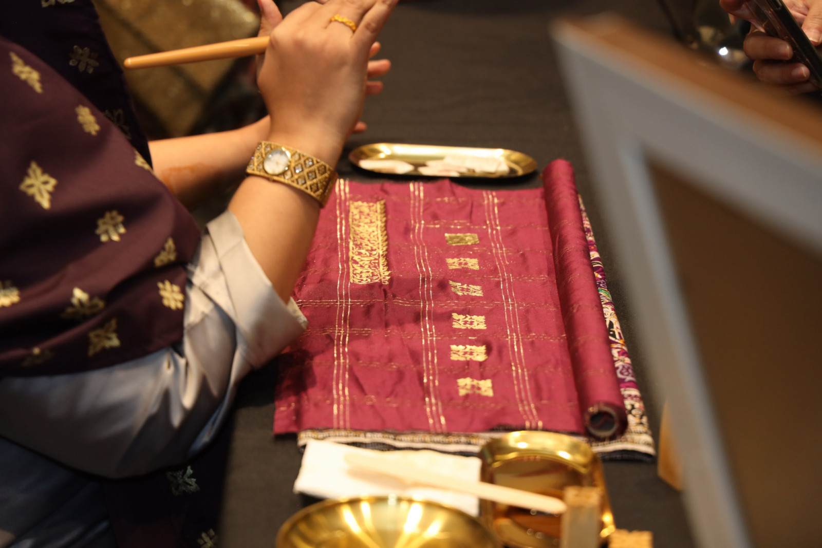 A demonstration of the traditional textile art of ‘telepuk’ using gilded gold leaf