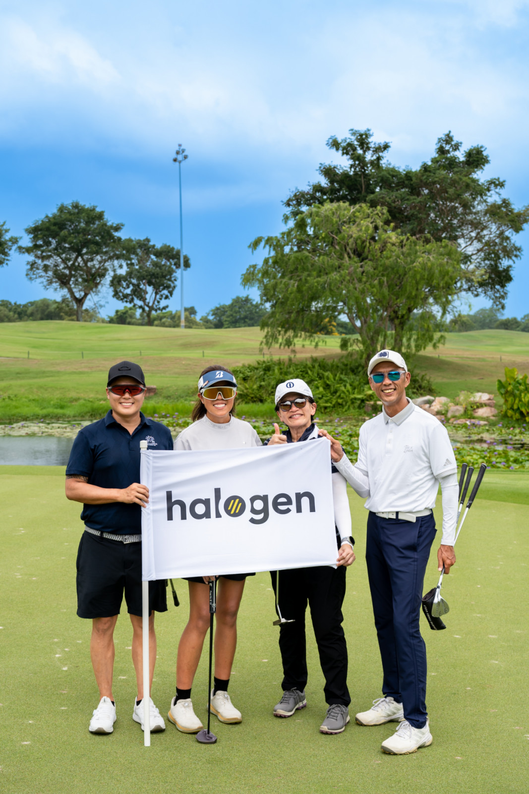 Golfers pose with the Halogen flag during the charity tournament at Tanah Merah Country Club’s Tampines Course