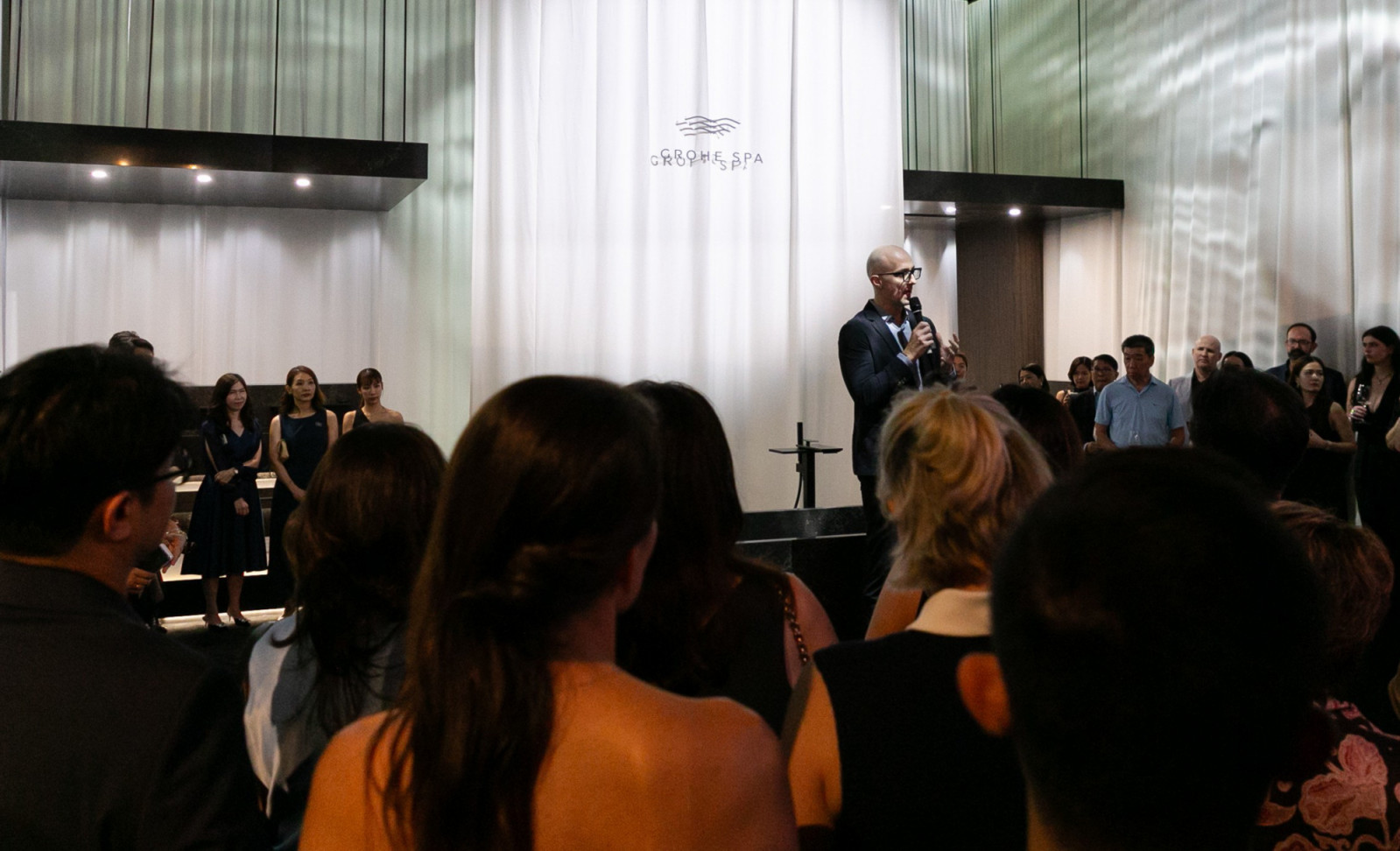 Antoine Besseyre des Horts addresses guests in front of the Grohe Spa Allure Gravity bathtub