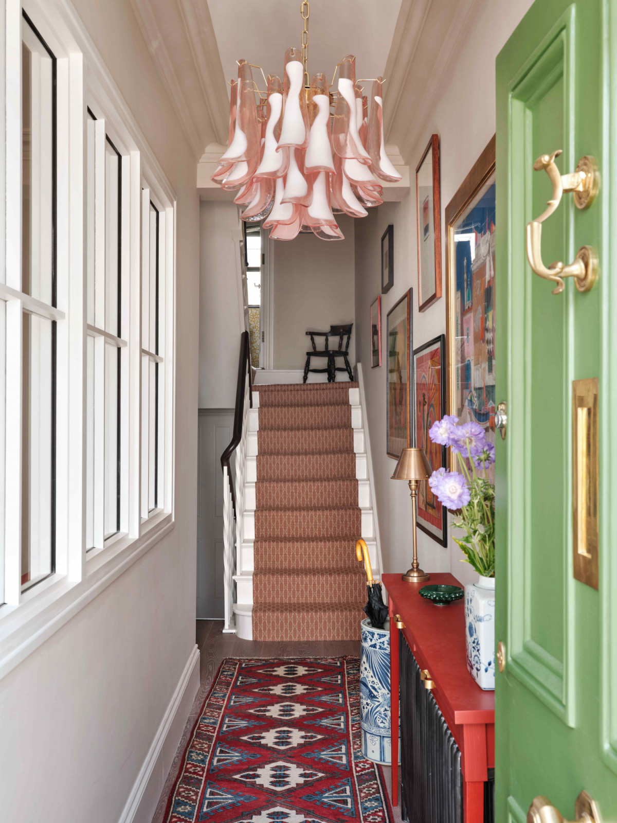 The initially dark and enclosed entry hallway where the staircase was opened up and an internal window brings in more light