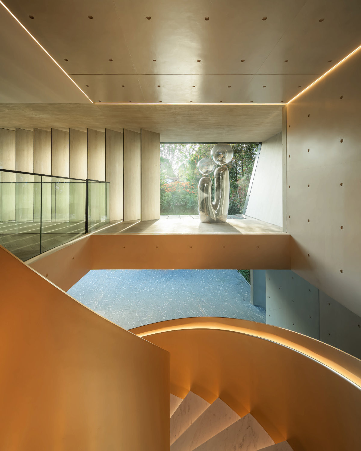 The chrome-finished sculpture and facade fins, seen here from the stairs, interact with light and shadow, a nod, says the owner, to Tadao Ando’s signature play of shadow on concrete