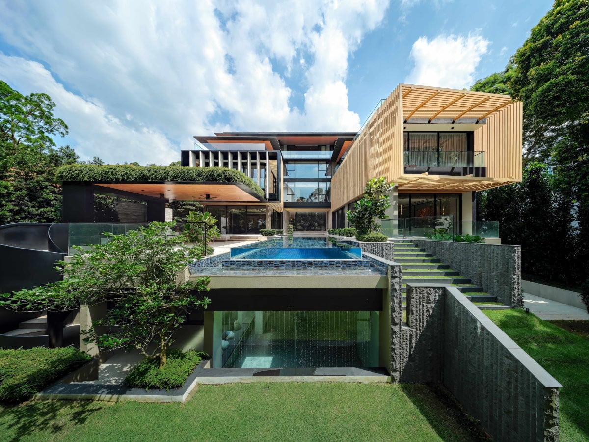 A daytime rear view of the Good Class Bungalow showcases how the right-wing volume extends outwards with timber frames that provide privacy and shade