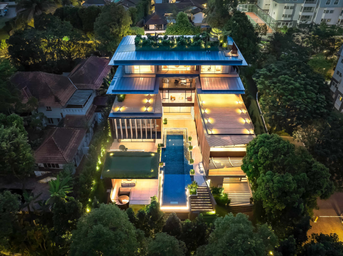 At night, the rear of this Good Class Bungalow glows around its lap pool, the spine between two asymmetrical wings