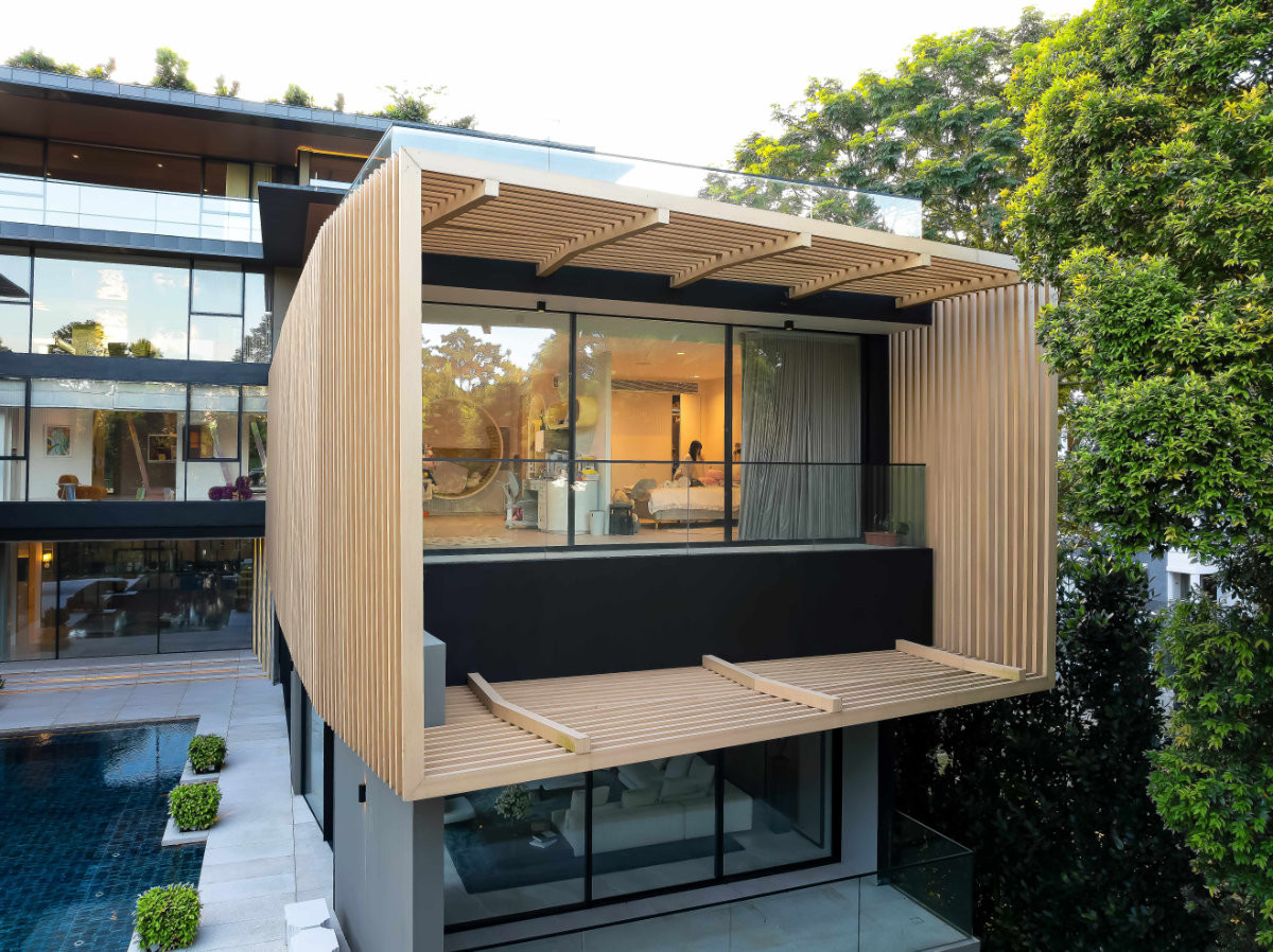 A child’s bedroom sits within a timber-slatted box that projects from the right wing, the slats filtering light while screening it from view