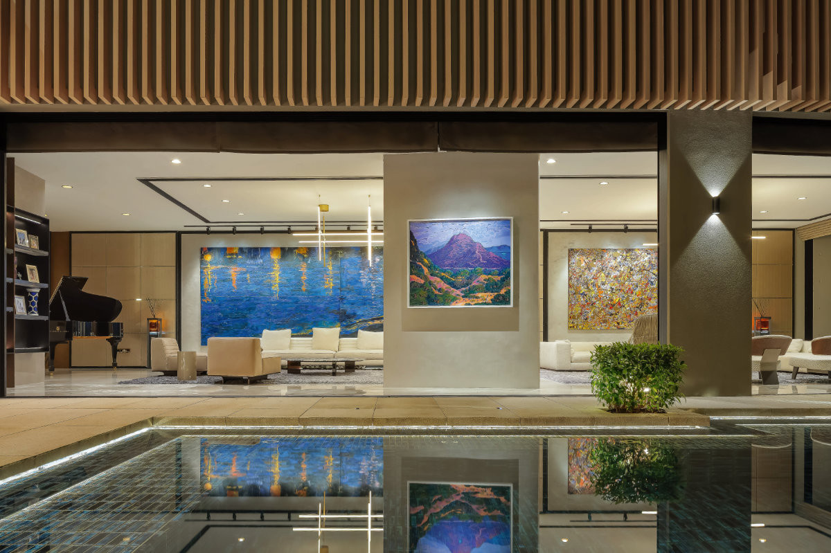 The living room pairs a restrained material palette with bold contemporary artworks that enliven the space.