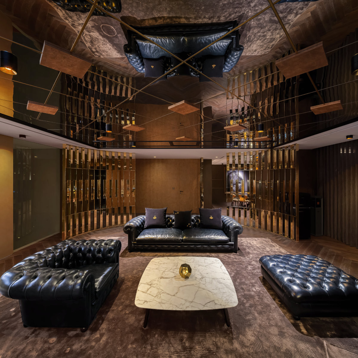 The entertaining area’s seating, dressed in a dark colour palette with Poltrona Frau Chesterfield leather sofas, speaks of refined elegance beneath mirrored ceilings