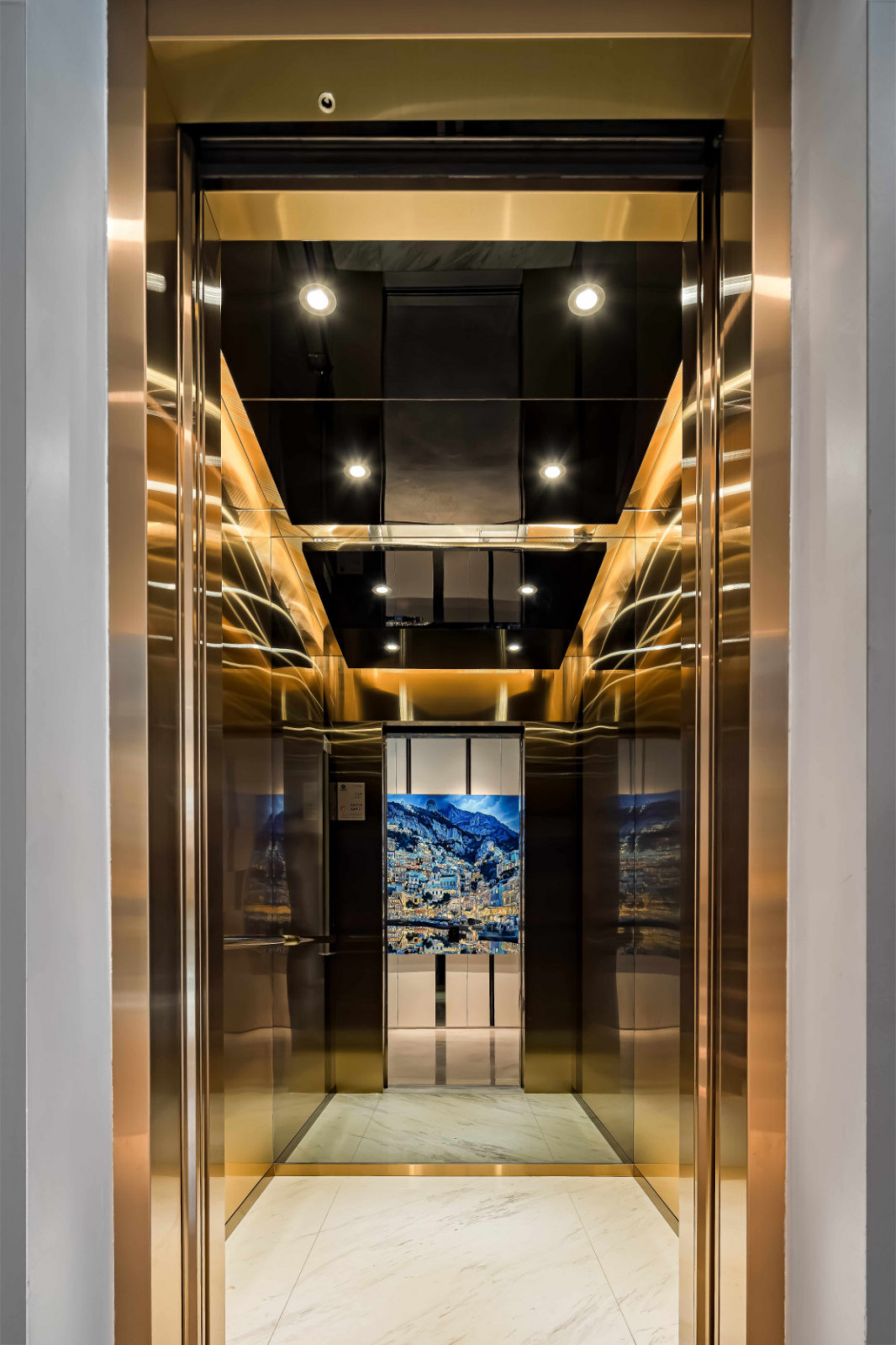 Even the lift is treated as a frame: its brass-lined interior reflects Seth Armstrong’s “Positano”, commissioned for the couple’s tenth wedding anniversary