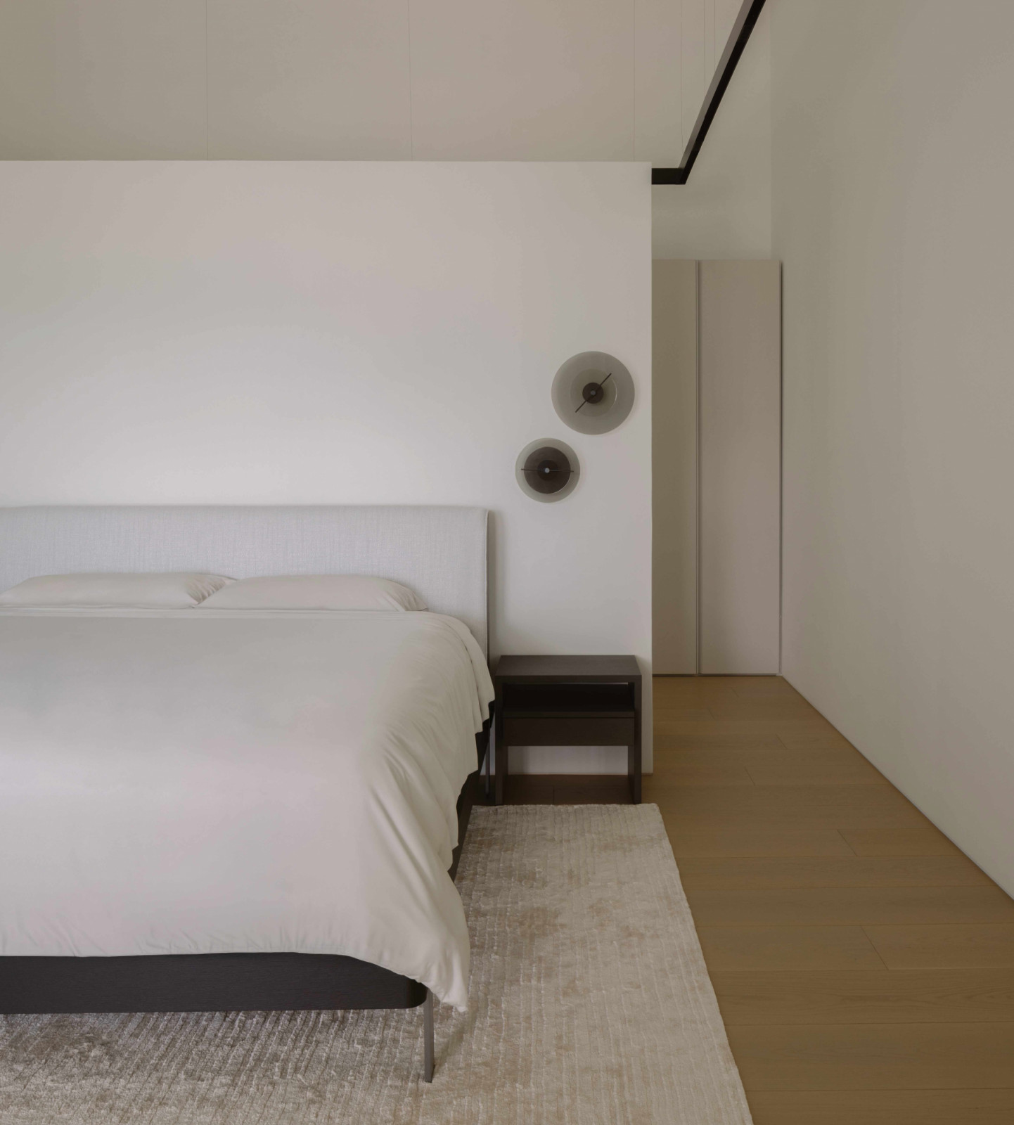 The master bedroom, where the angular headboard is paired with circular wall discs