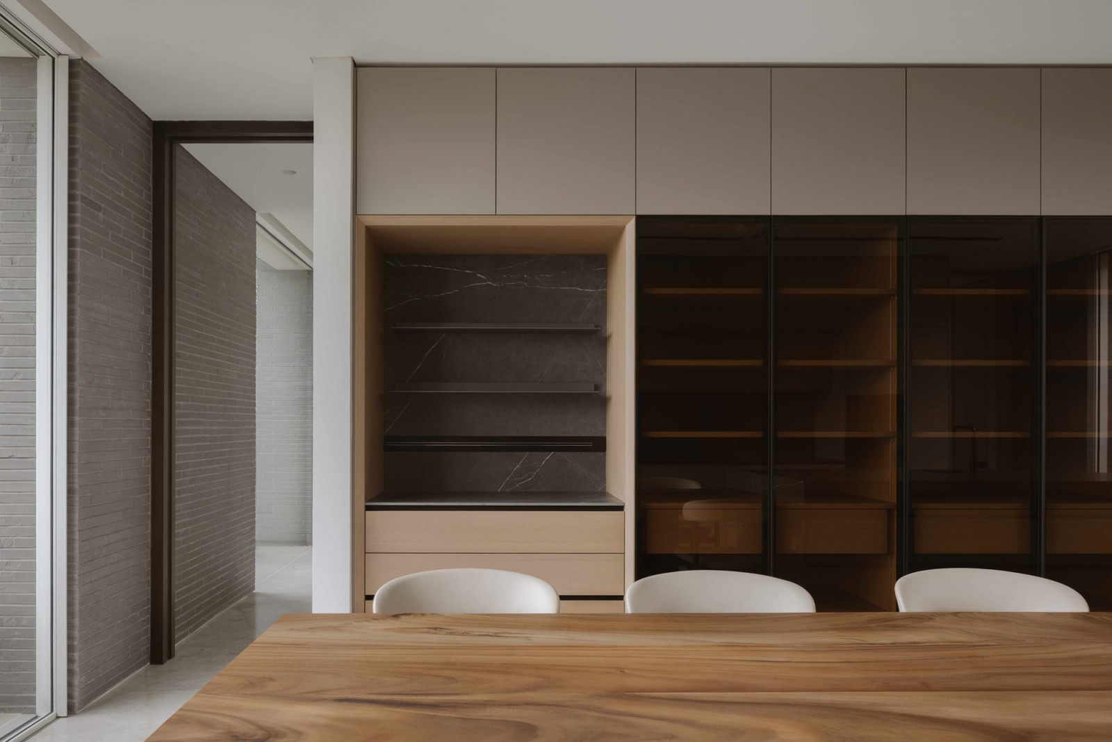Kitchen cabinetry with a dark interior adds depth to the bungalow’s pale, pared-back palette