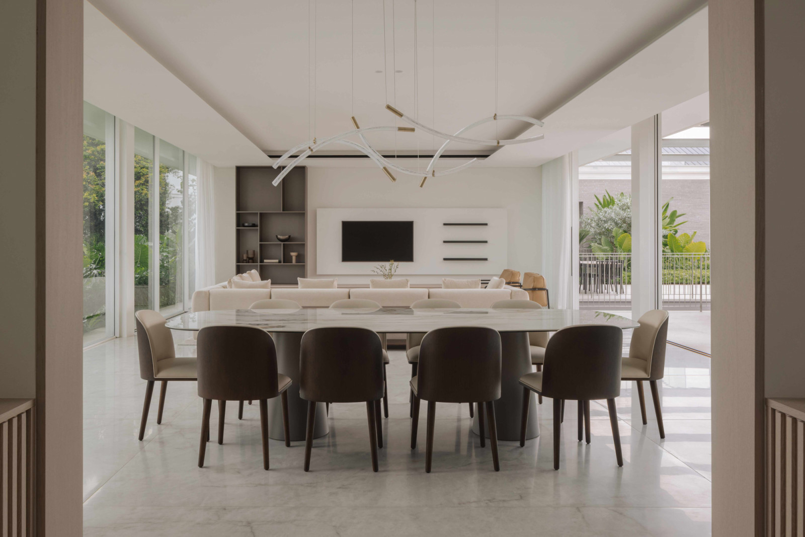 Sculptural pendants of tangled brass and glass hover over the dining table