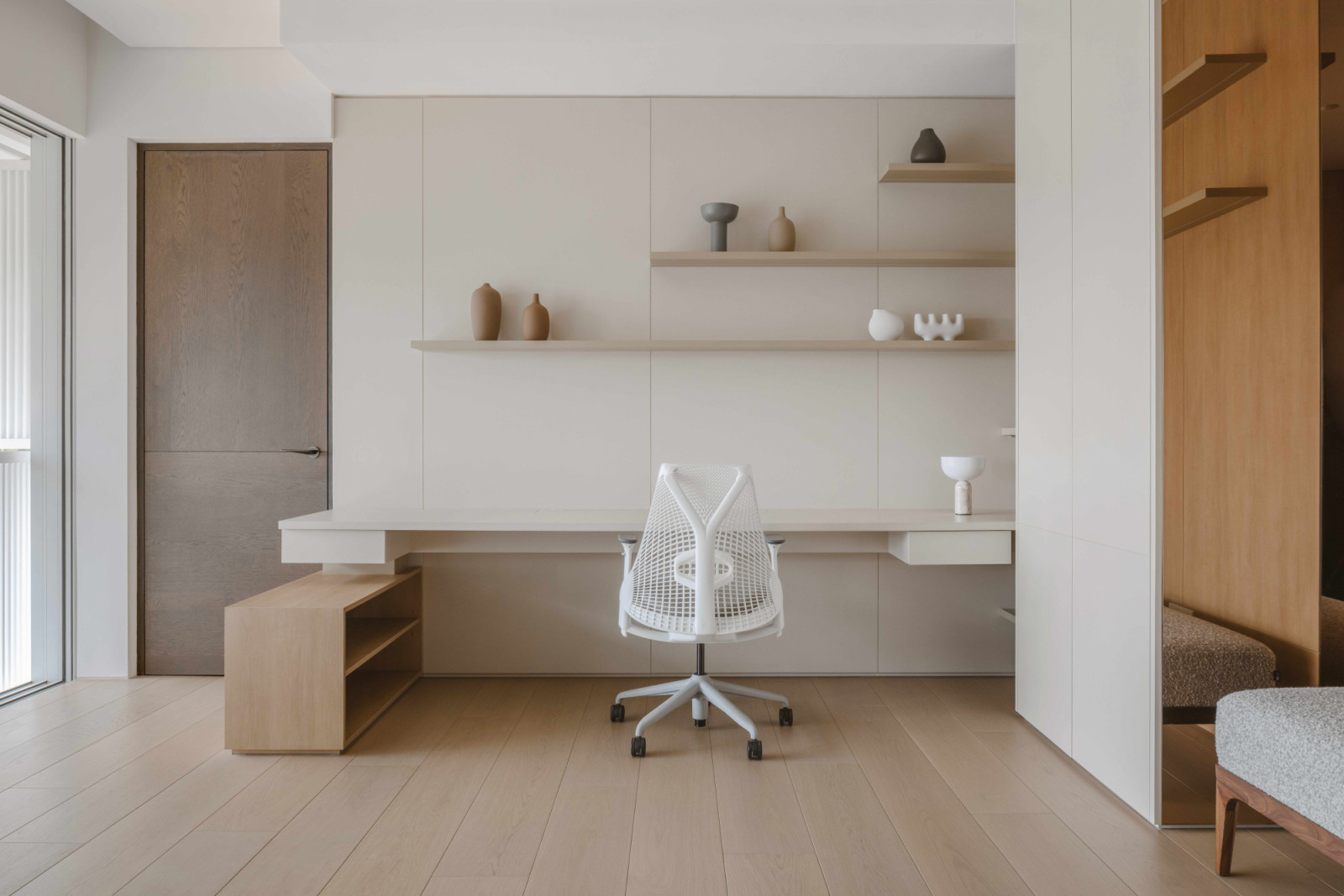 A streamlined desk built into open shelving in the study