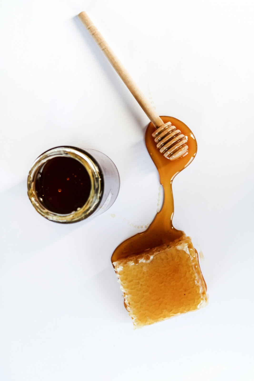Raw honeycomb, a jar of honey, and a wooden dipper showcase the natural sweetness of honey.