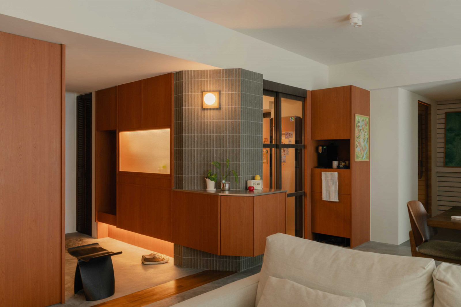 A tiled column and illuminated display niche mark the transition between the communal zones